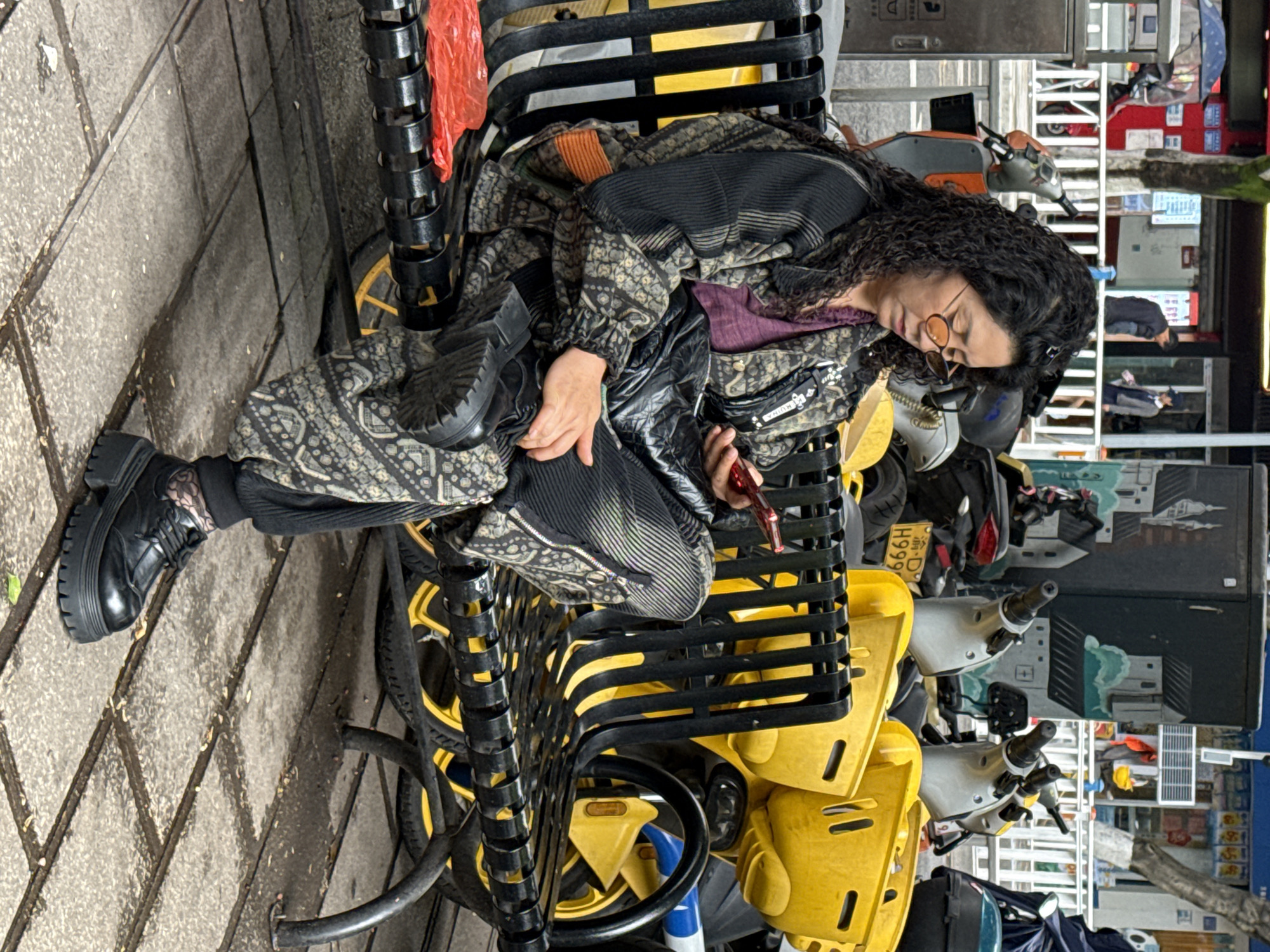 Woman sits on bicycle rack in Shapingba District