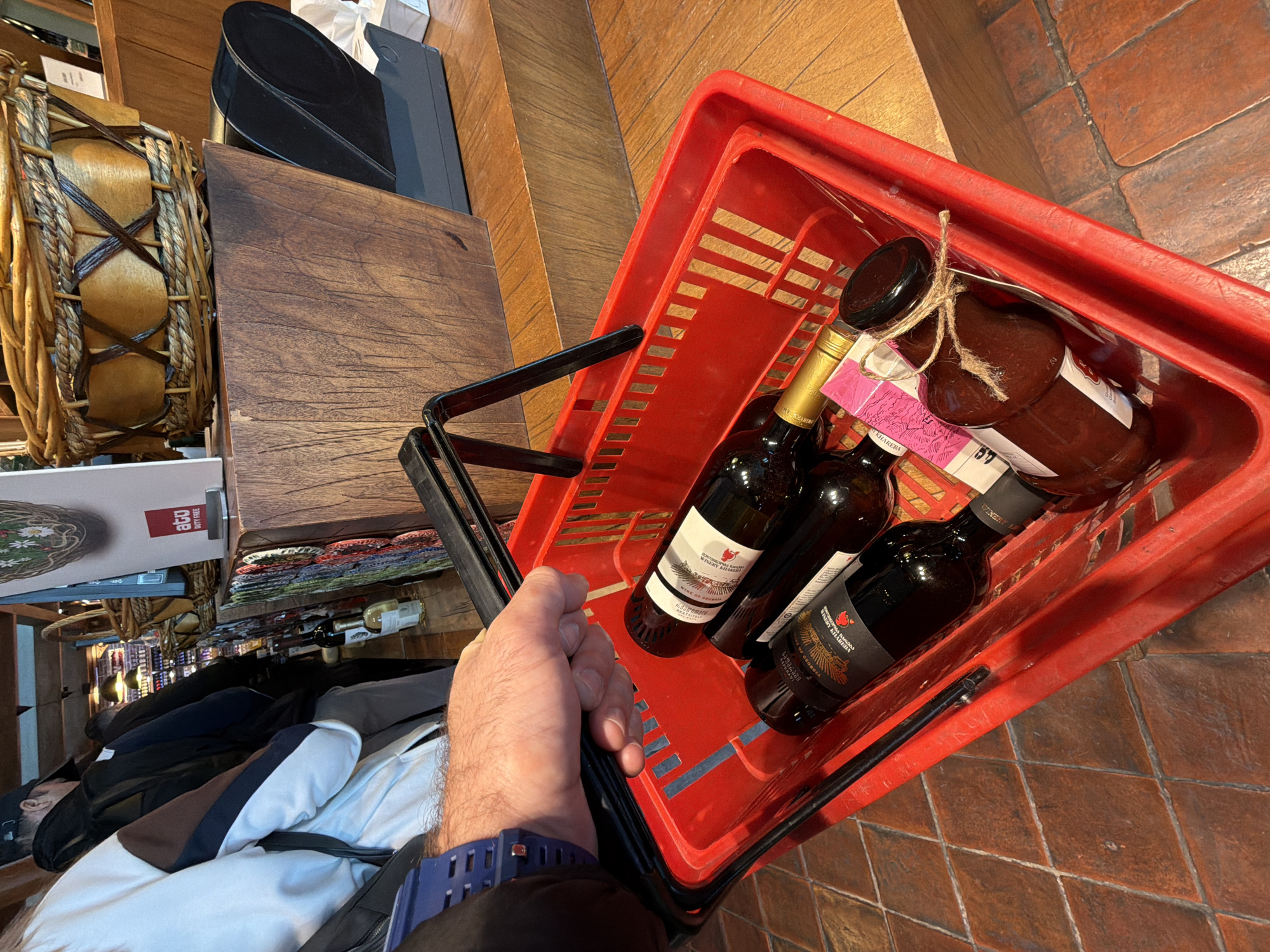 Shopper carries wine and sauce in basket in Georgia
