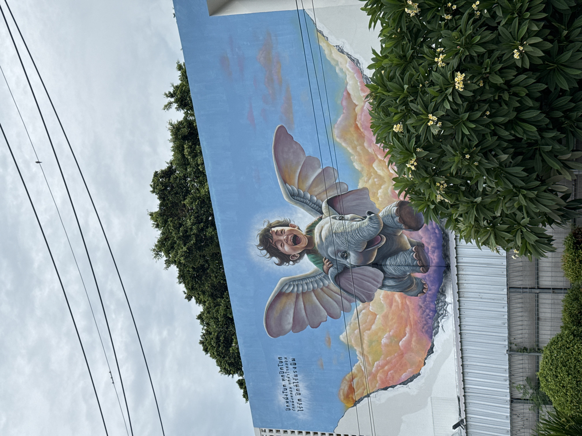 Whimsical mural shows child riding winged elephant in Thailand