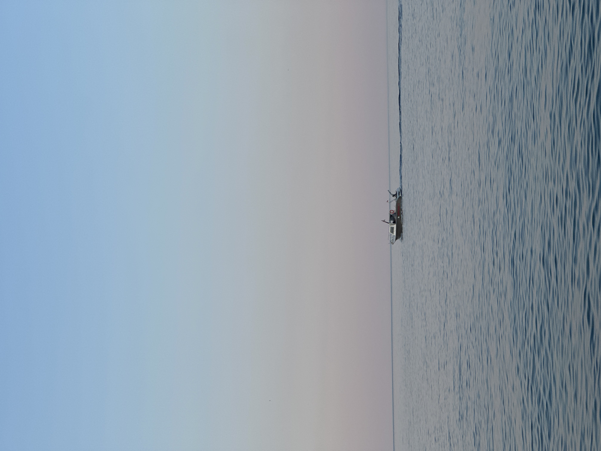 Dawn on the Montenegrin coast — boat on still water, tide pools below