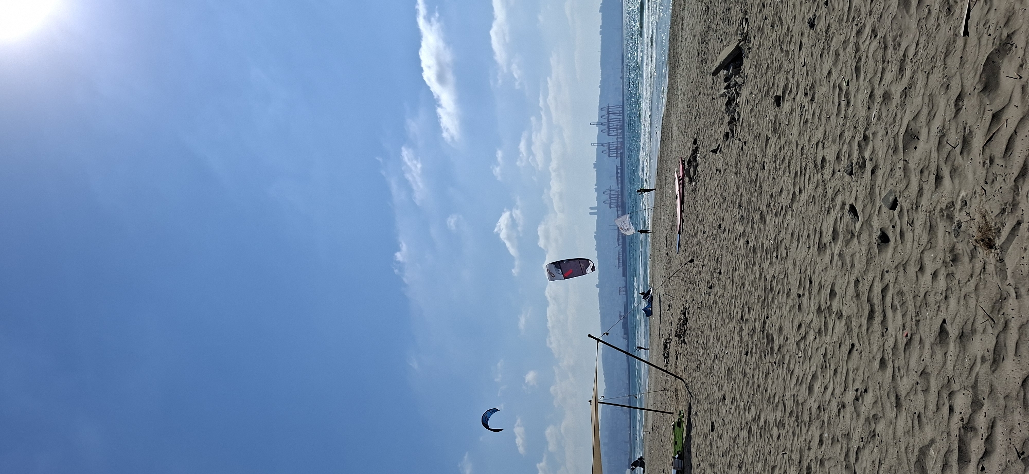 Kitesurfers and calm shoreline on a clear beach day