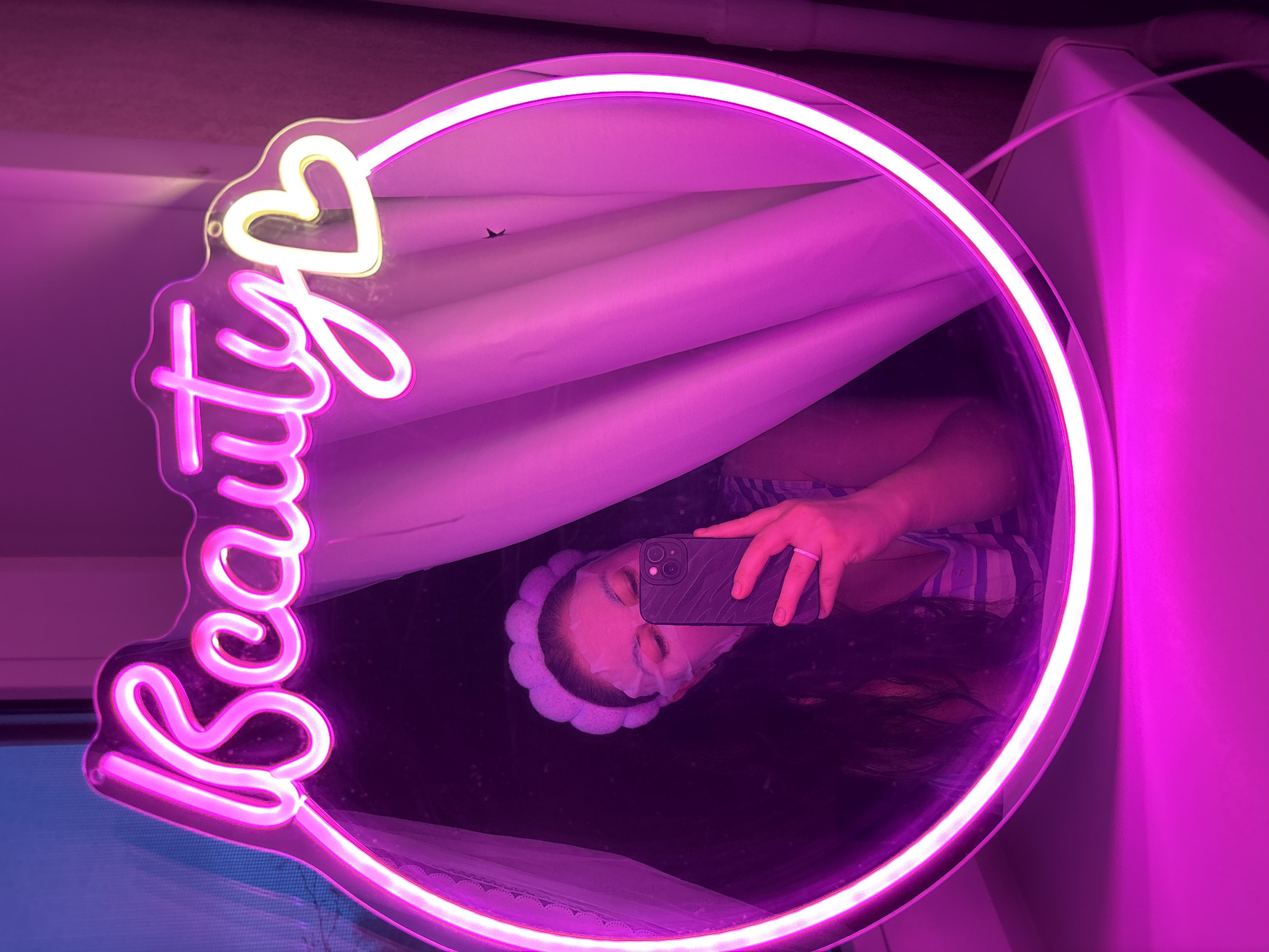 Person takes selfie at illuminated beauty mirror in Chaikovsky