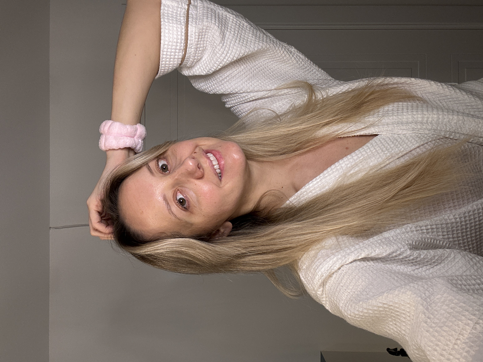 Woman performs evening skincare routine in Carnikava bathroom