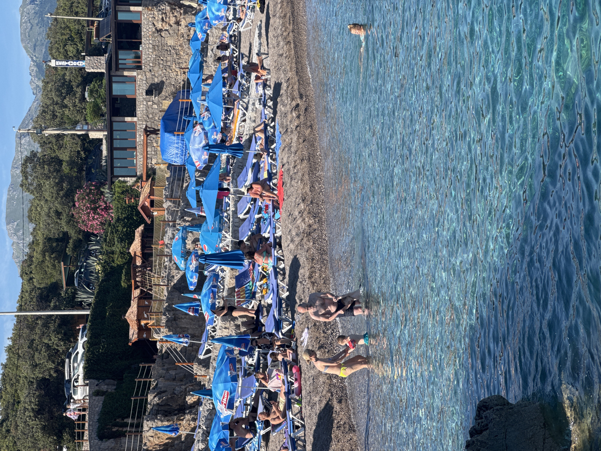 Summer beach day at Prijevor with water park and boats