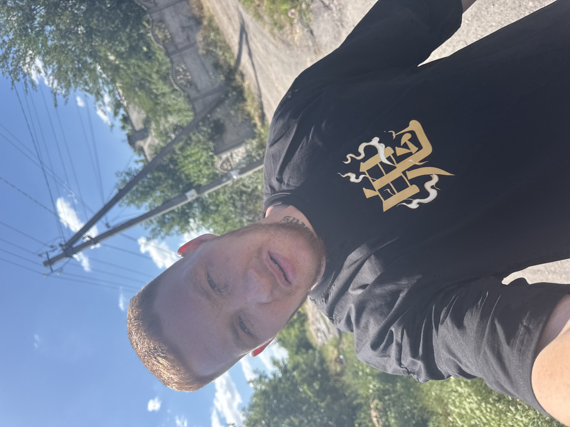 Selfies on a muddy dirt road, black tee with gold graphic