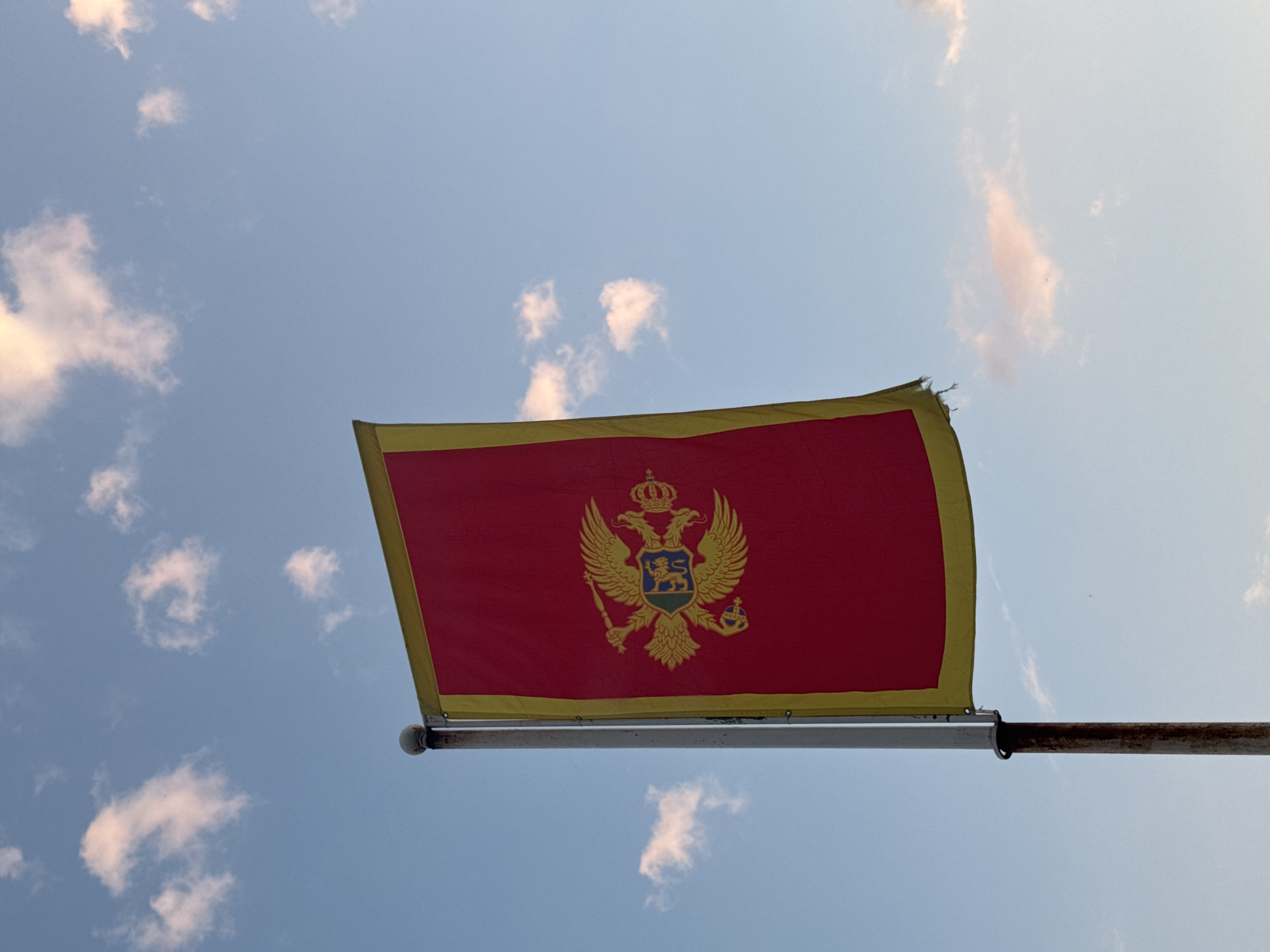 Montenegro flag observed flying in Podgorica under cloudy skies