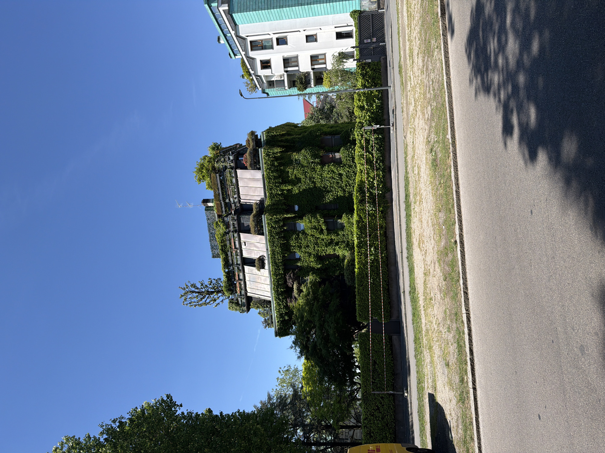 Green-integrated buildings observed in sunlit Milan street scene