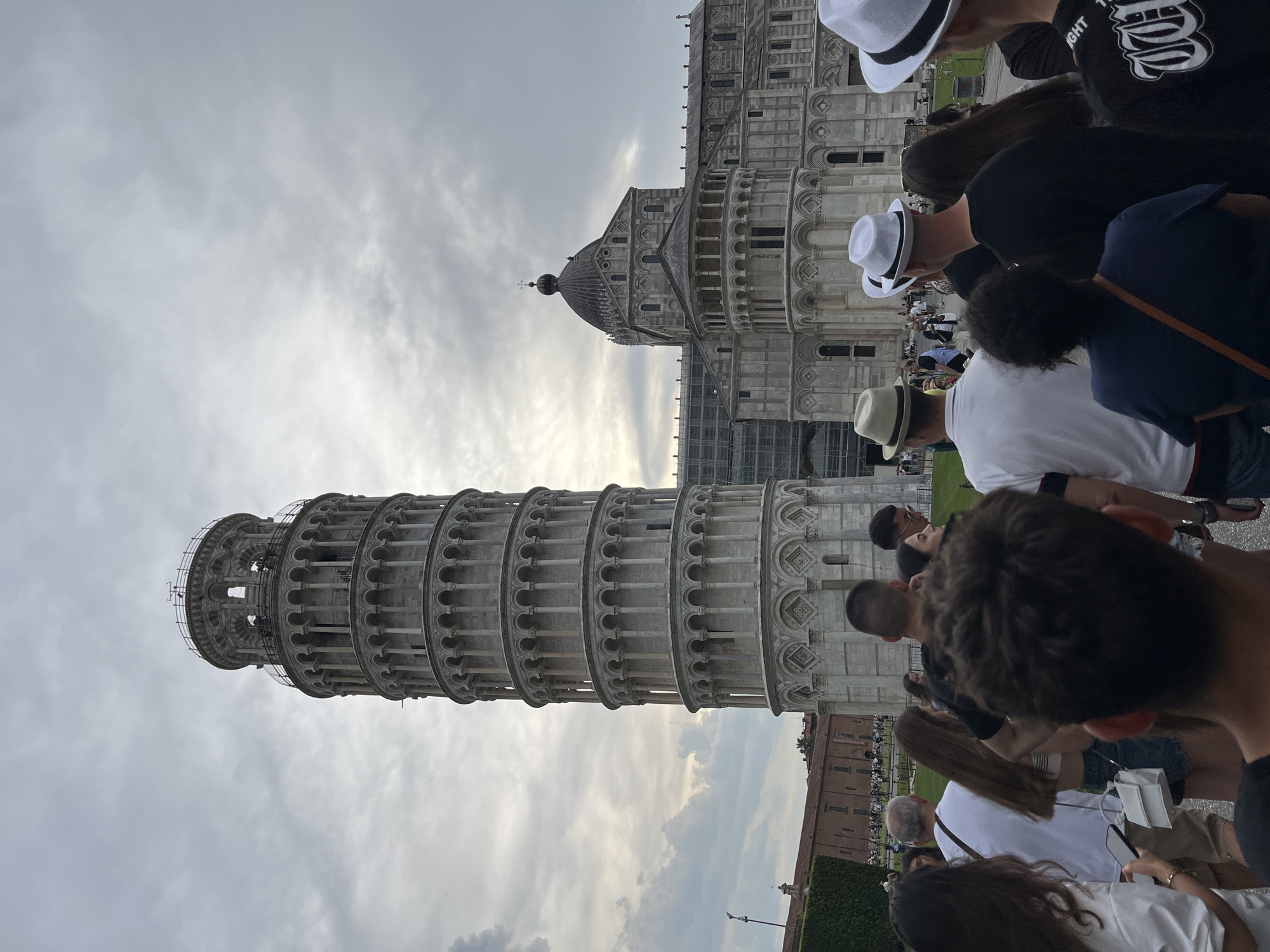 Tourists pose and take selfies at Leaning Tower of Pisa