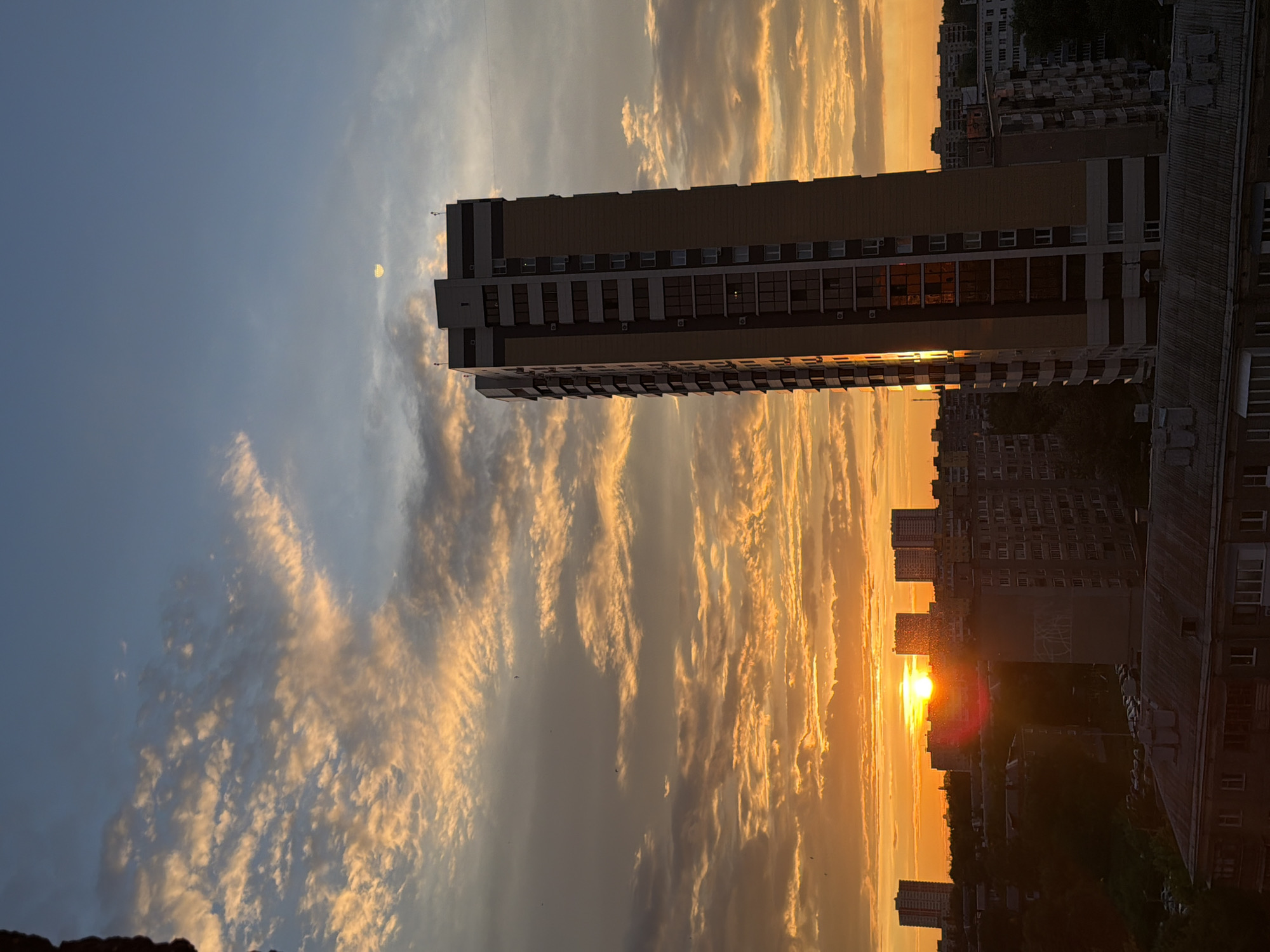 Urban sunset illuminates residential towers across city landscape