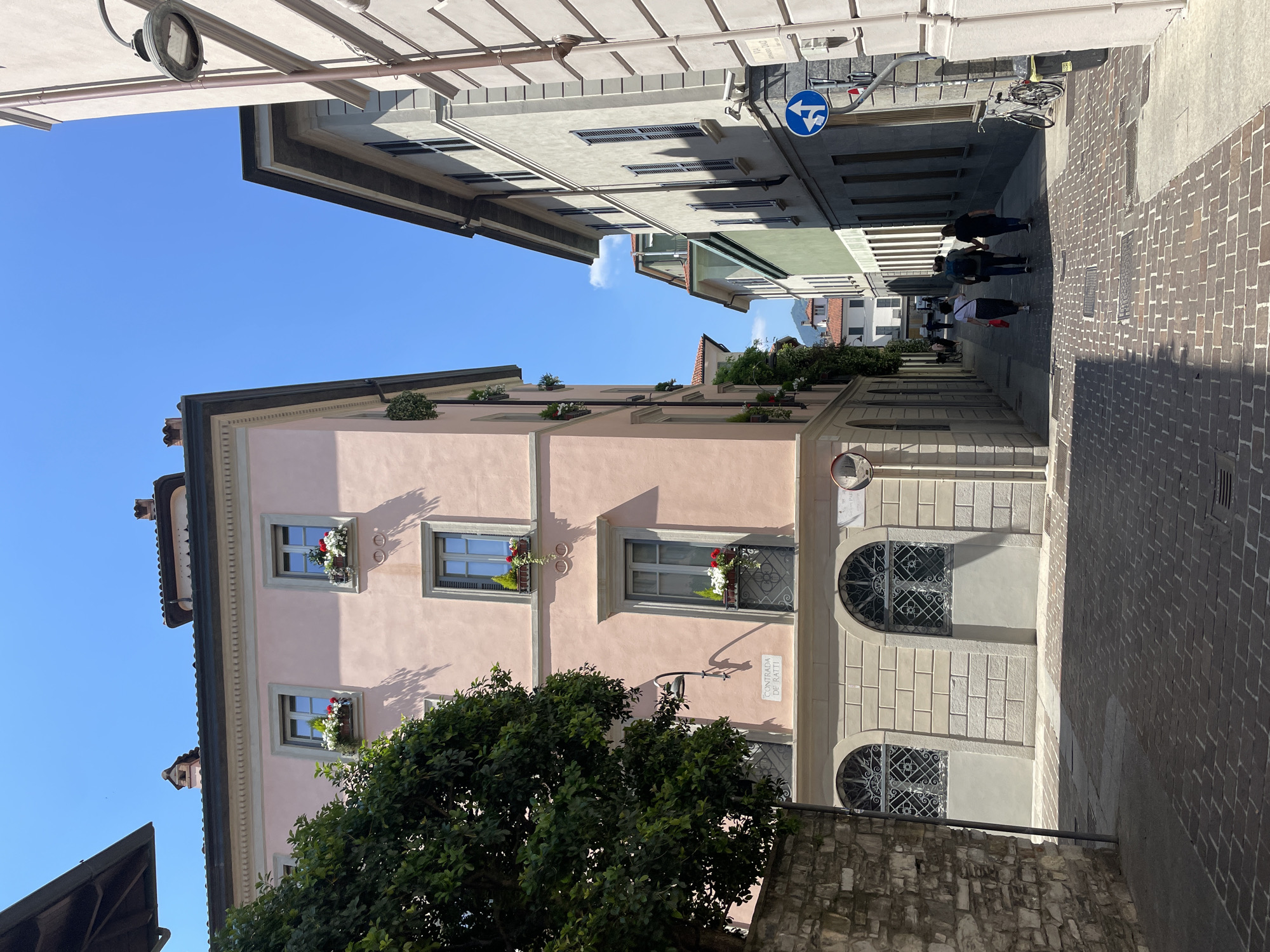 Street scene documented in Como showing pink building with flowers
