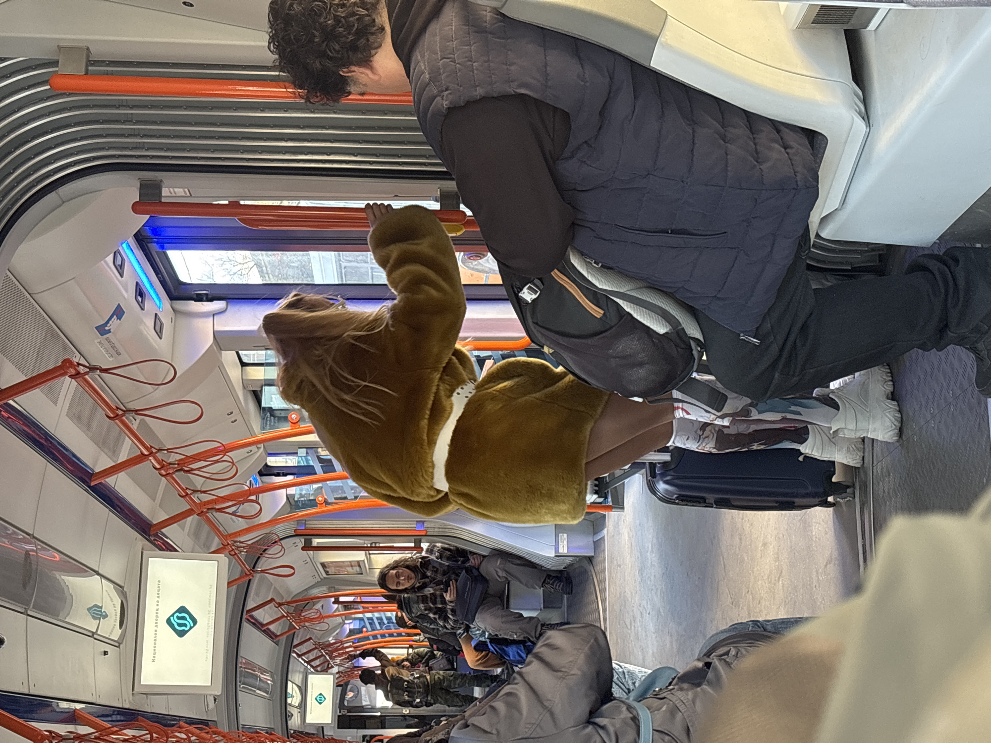 Man in dark vest rides Sofia subway during afternoon commute
