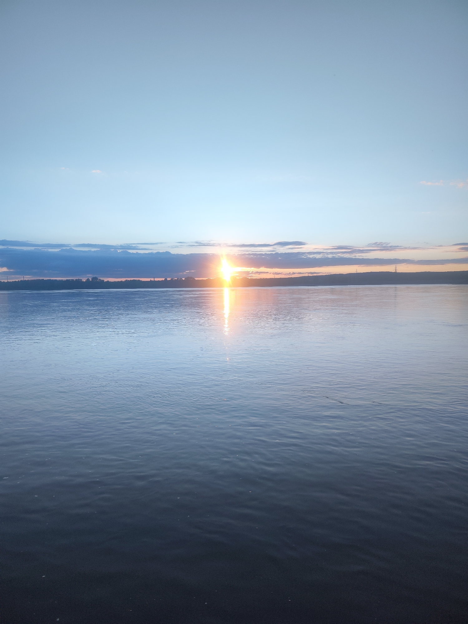 Sunset documented over water body near Noviy, Russia