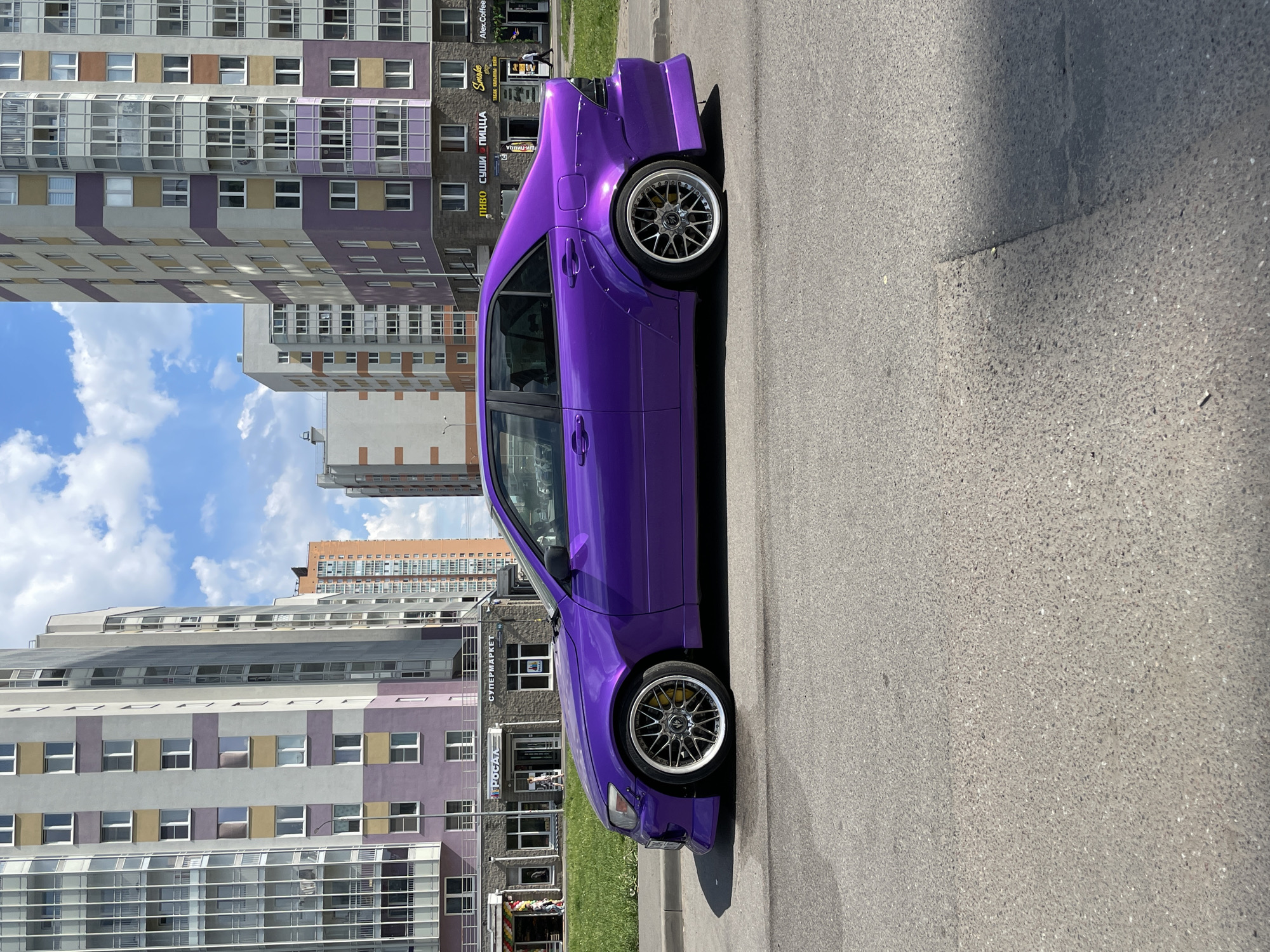 Children play, purple car parked in Russian city