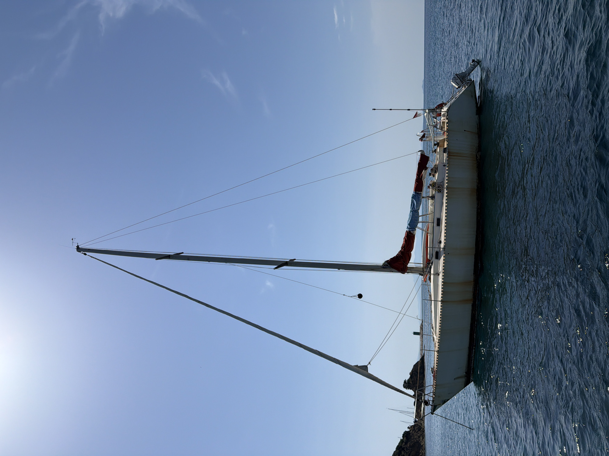 Sailboat anchored and motorboat underway off Punta Ala