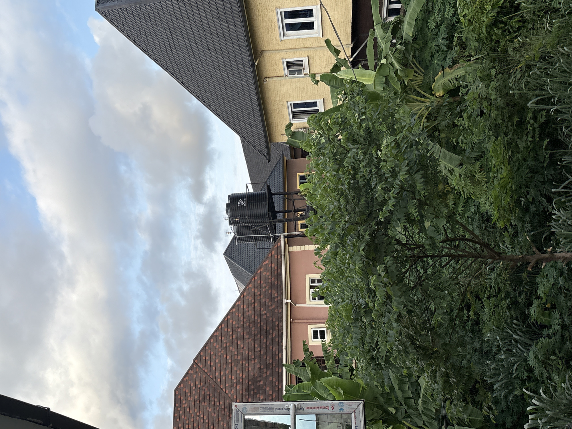 Obosi residential streets under heavy clouds, July afternoon