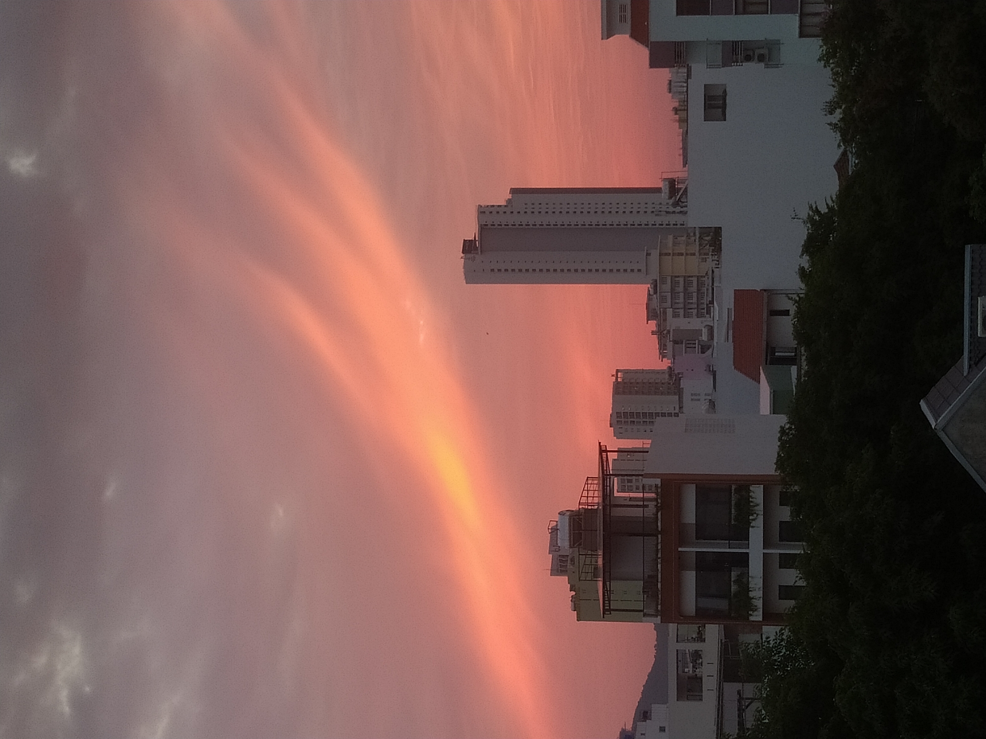 City skyline glows under a pink and orange sunset