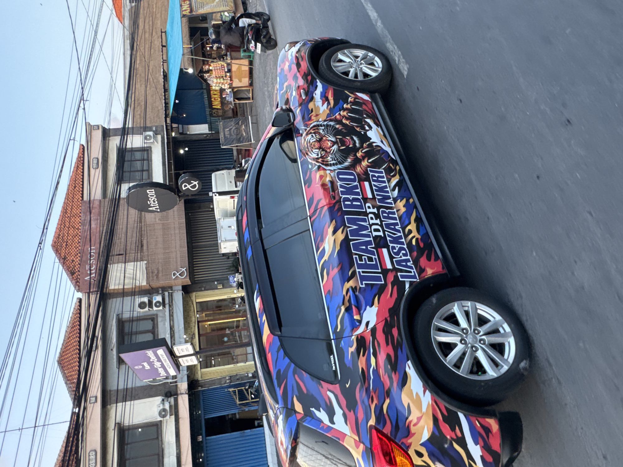 Denpasar evening rush hour, sunset light, camouflage car in traffic
