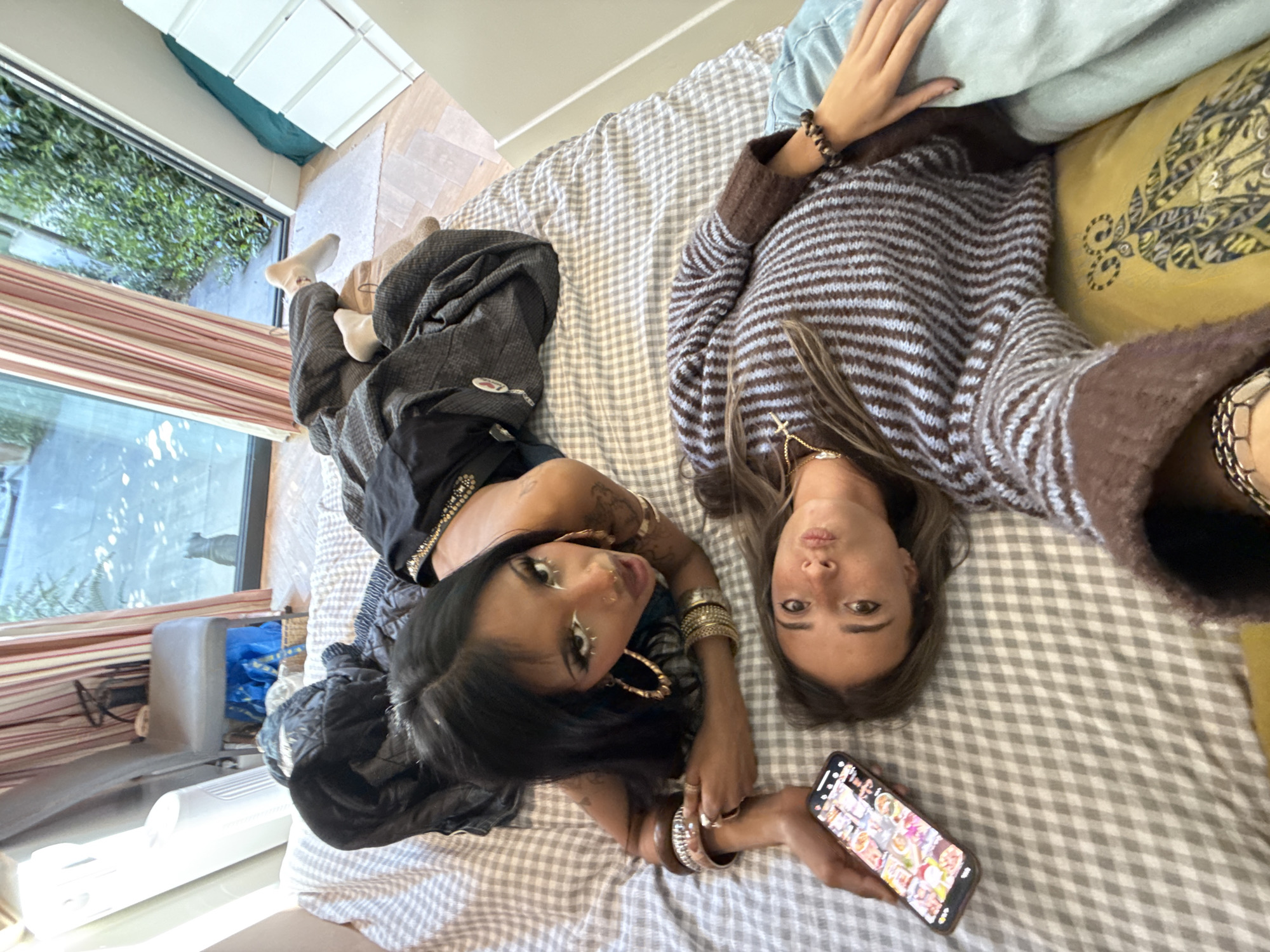Two women photographed resting on bed in London