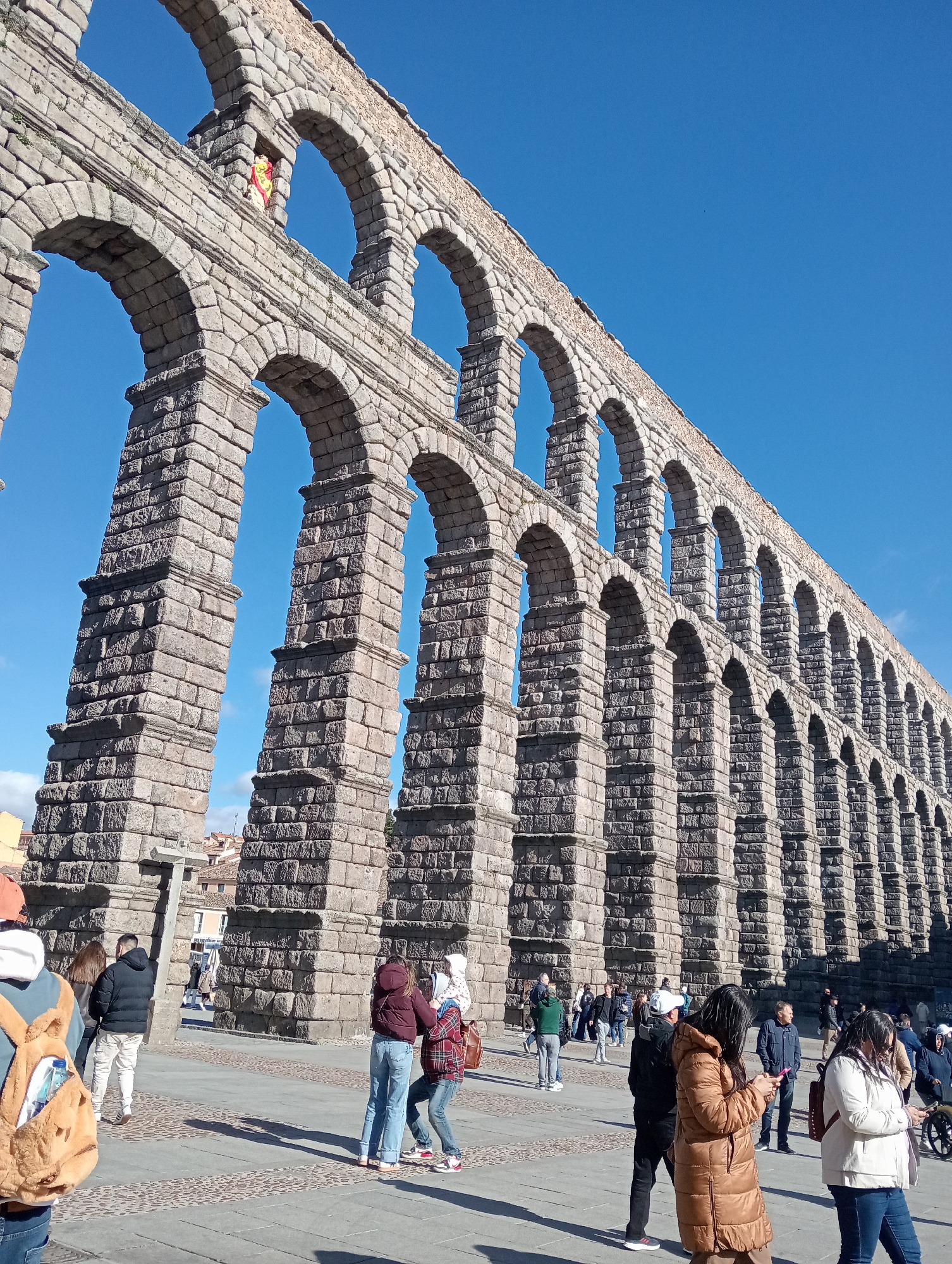 Tourists document afternoon visit to Segovia's Roman aqueduct