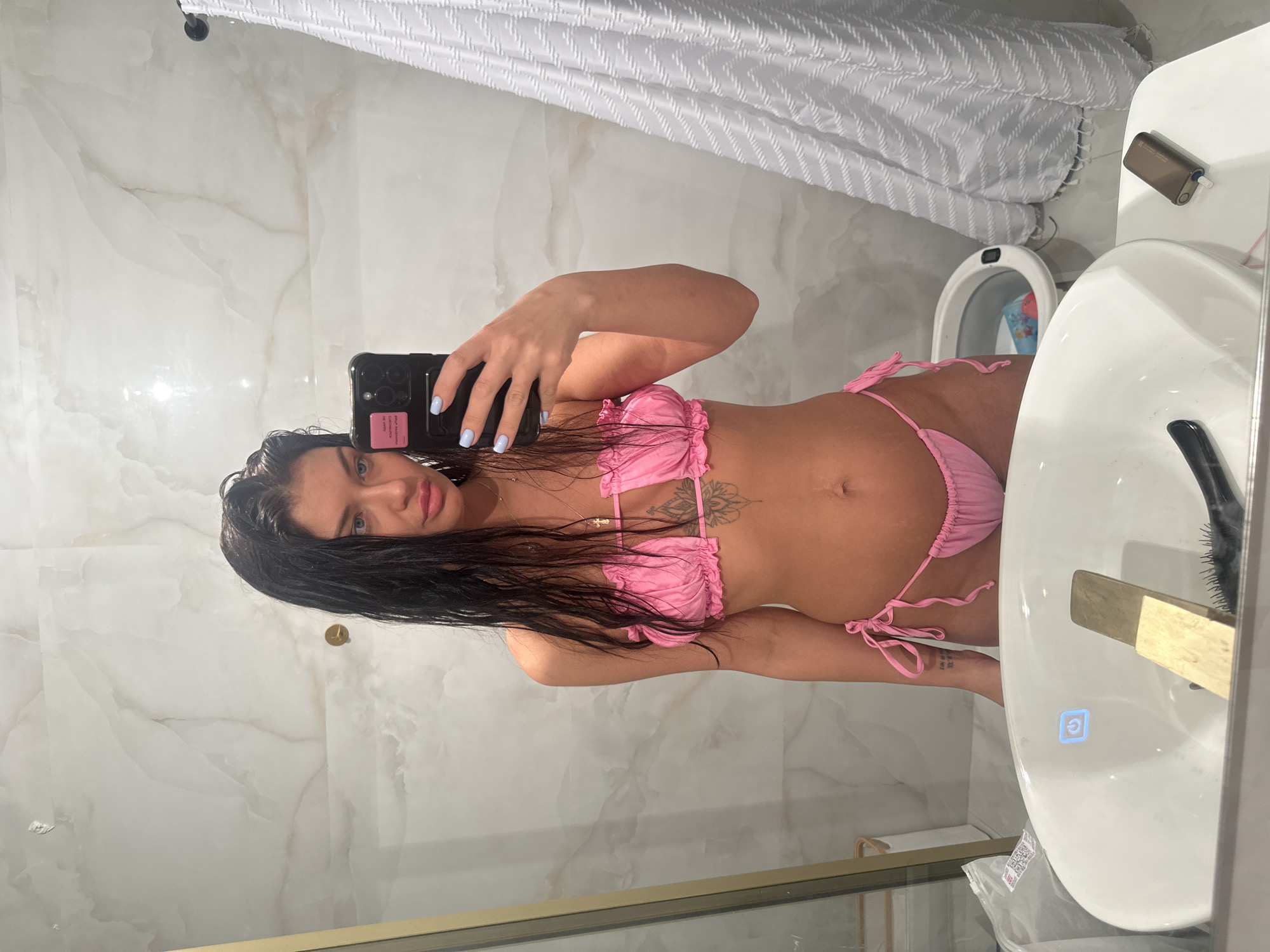 Woman takes bathroom selfie in pink bikini in Moscow