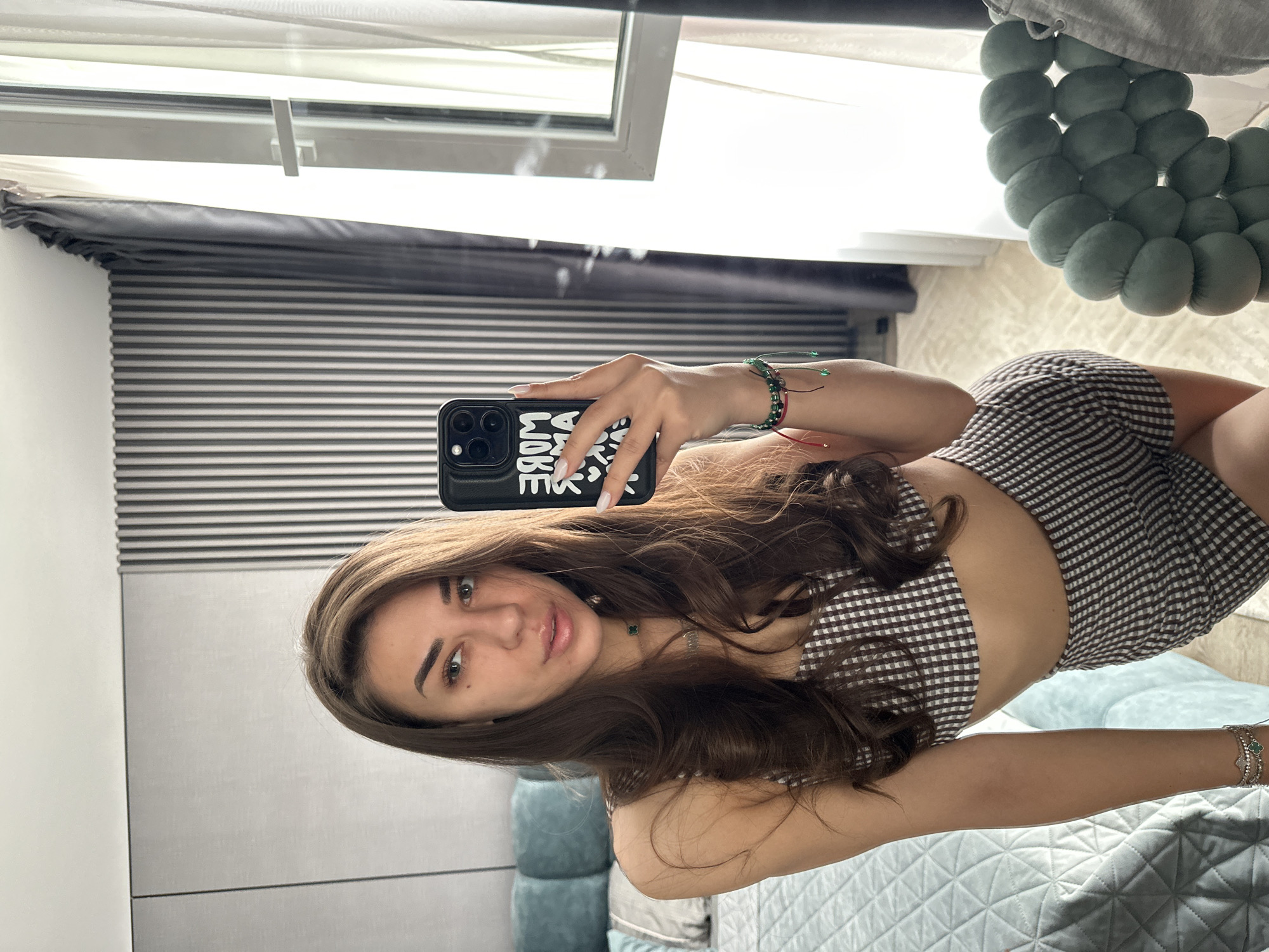 Woman takes multiple mirror selfies in checkered outfit, Sofia