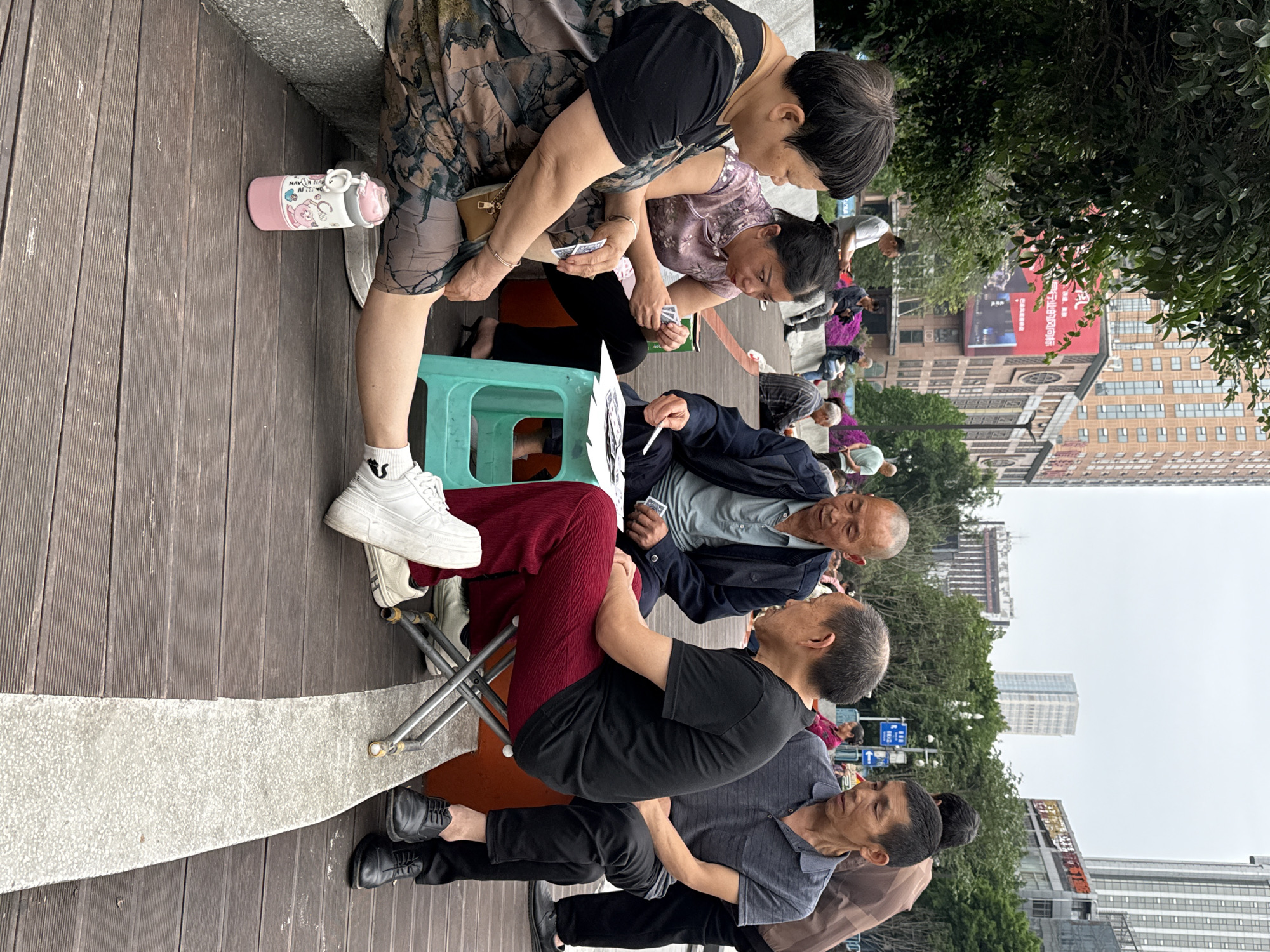 Elderly residents play cards on boardwalk in Nan'an District