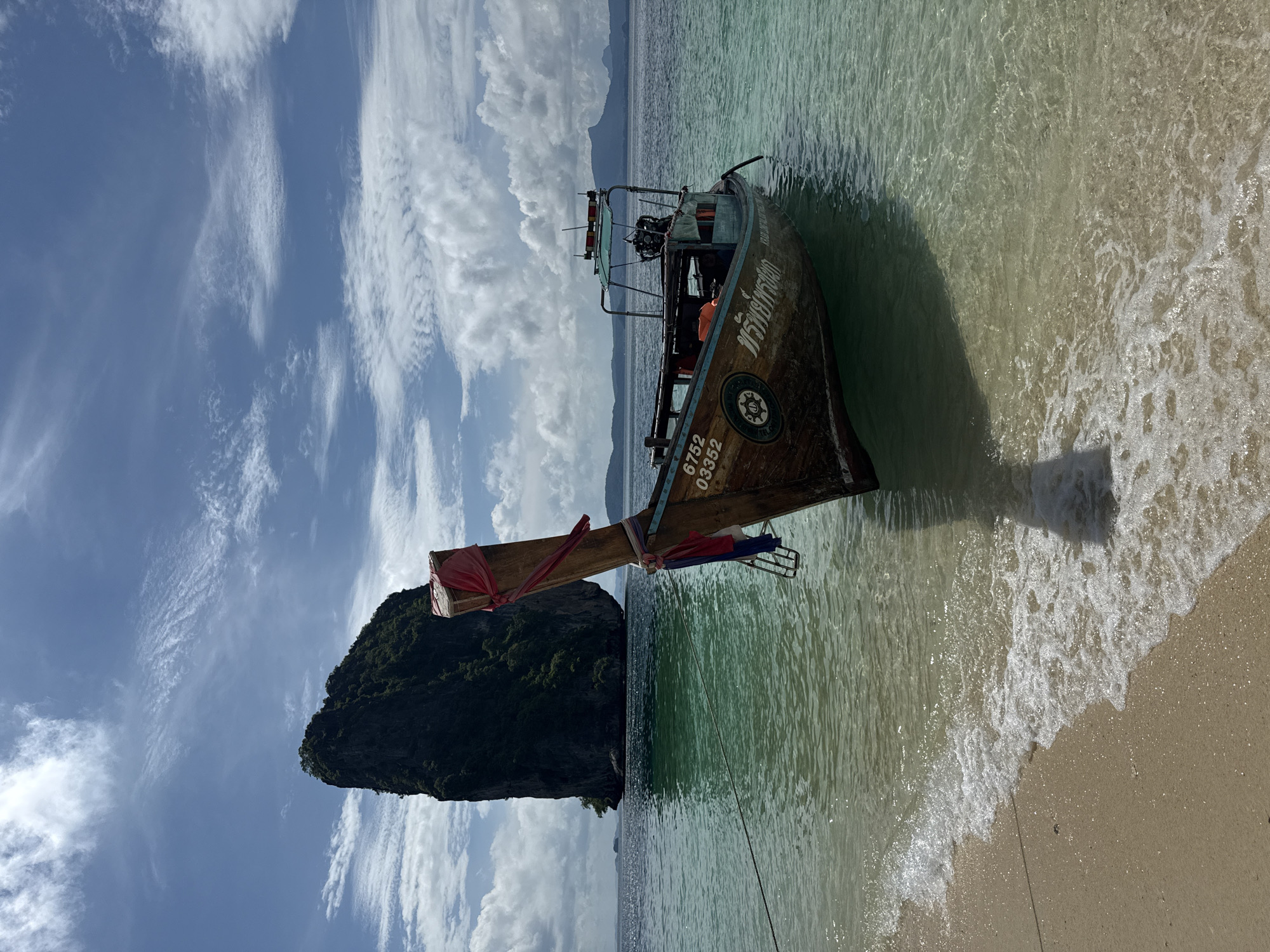 Longtail boat at Ban Ao Nang beach with limestone cliffs
