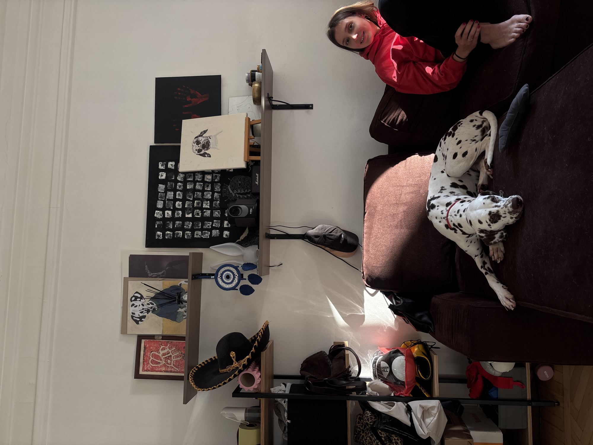 Woman relaxes with Dalmatian dog in sunlit Moscow apartment