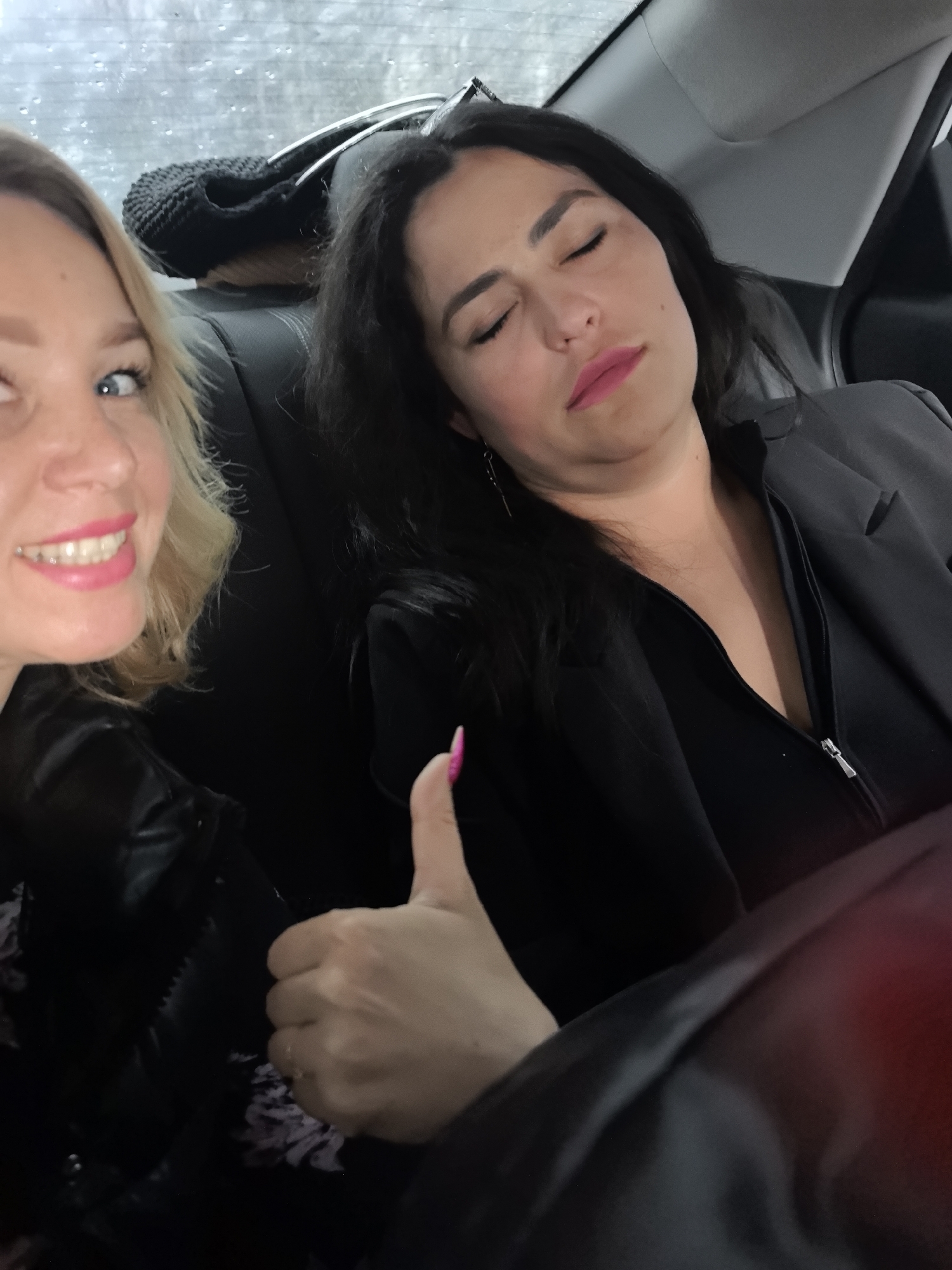 Women photographed smiling in vehicle backseat in Grishanki, Russia