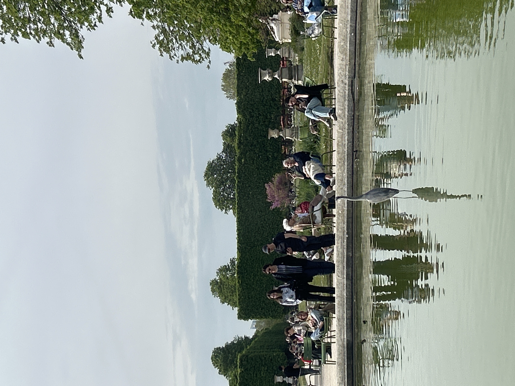 Parisians relax by Tuileries garden ponds during midday break