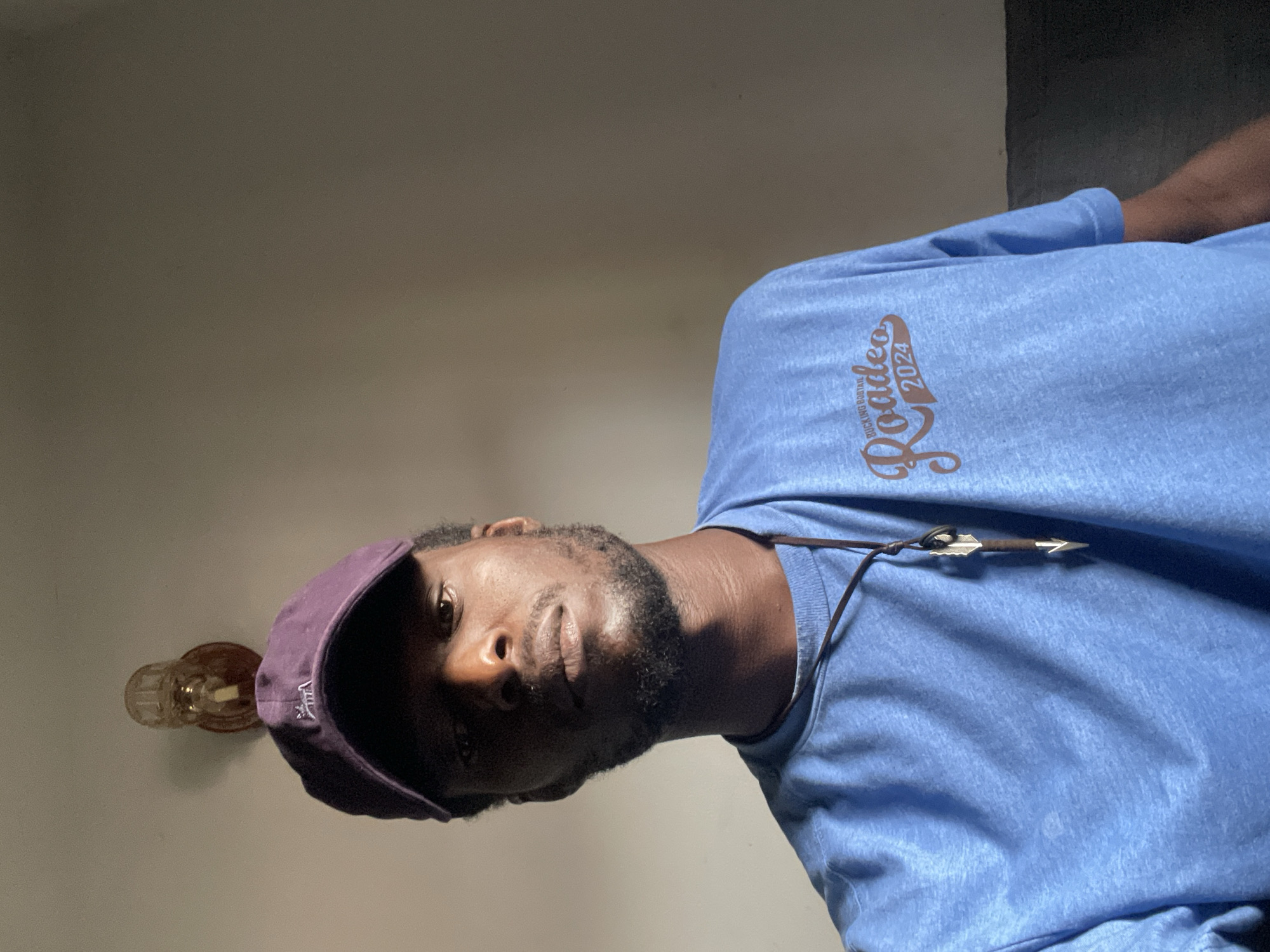 Selfie series in a dim Abuja room, mid-morning.