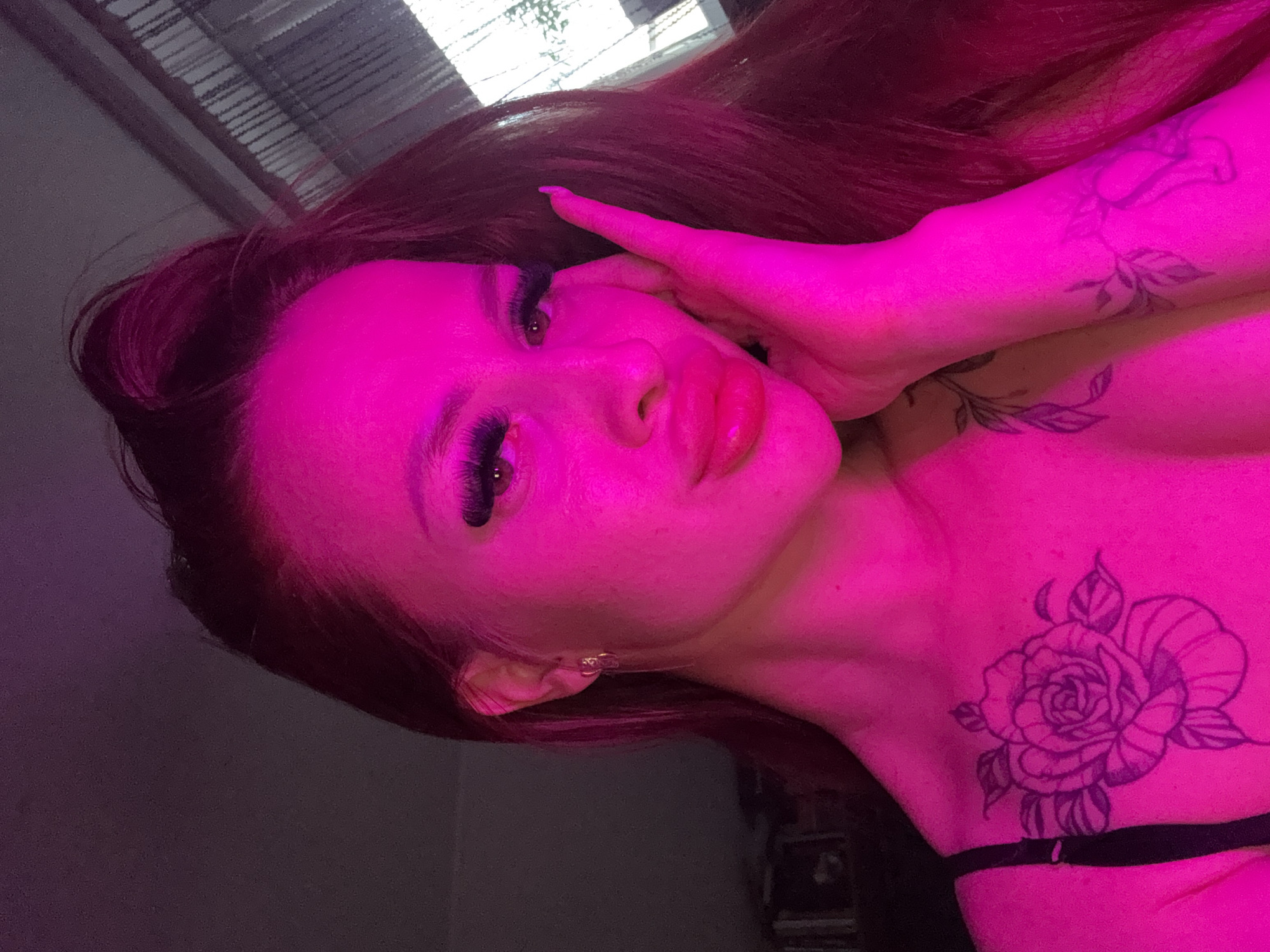 Woman takes selfies under colored lighting in Simferopol residence