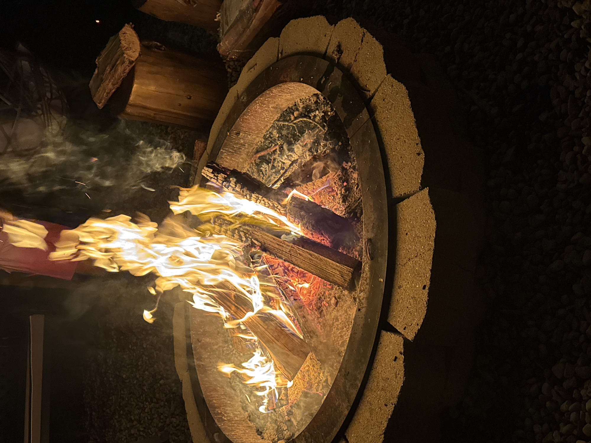 Late night outdoor gathering features fire pit, music, games