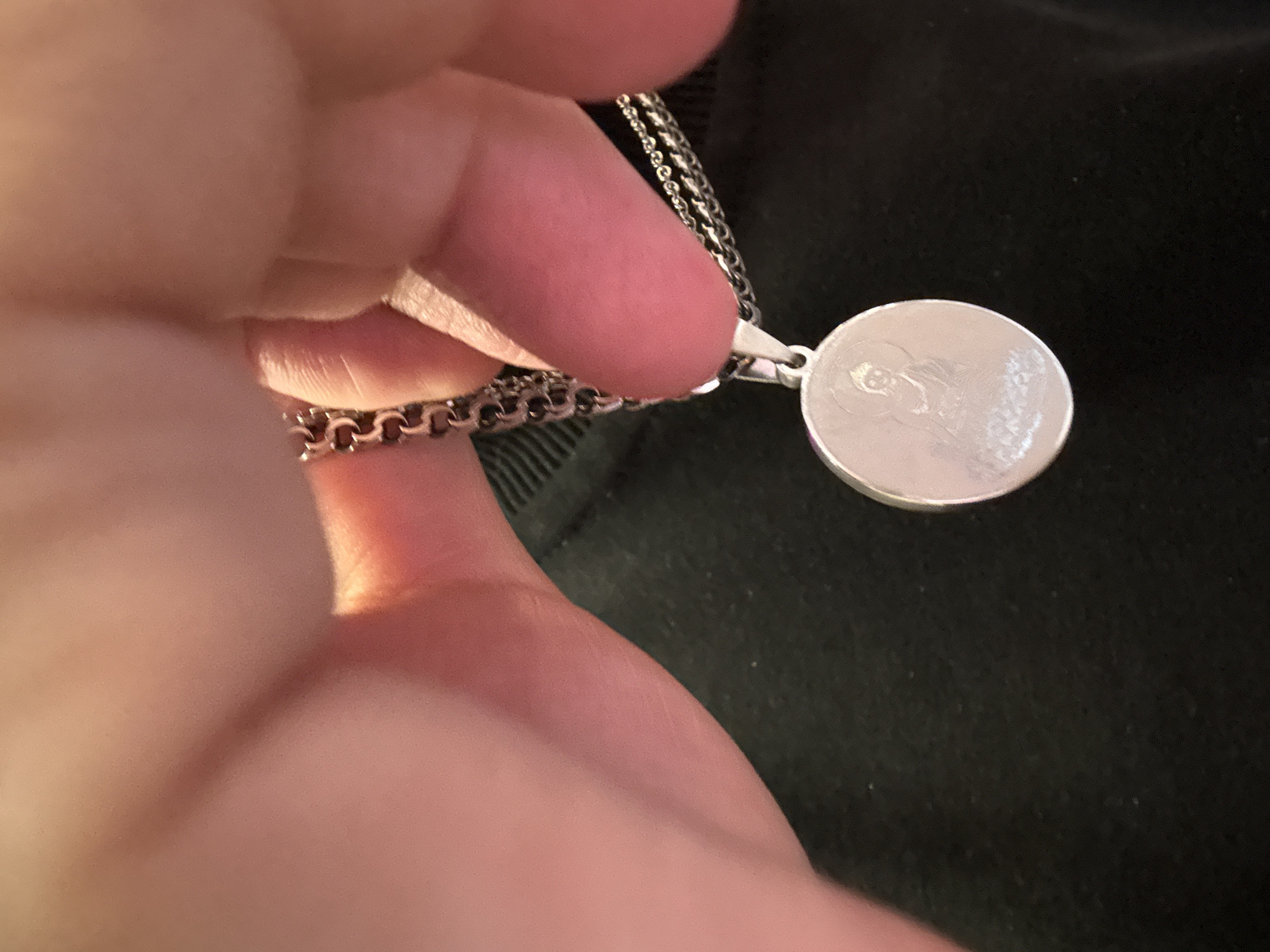 Silver Buddha pendant examined up close in Khimki