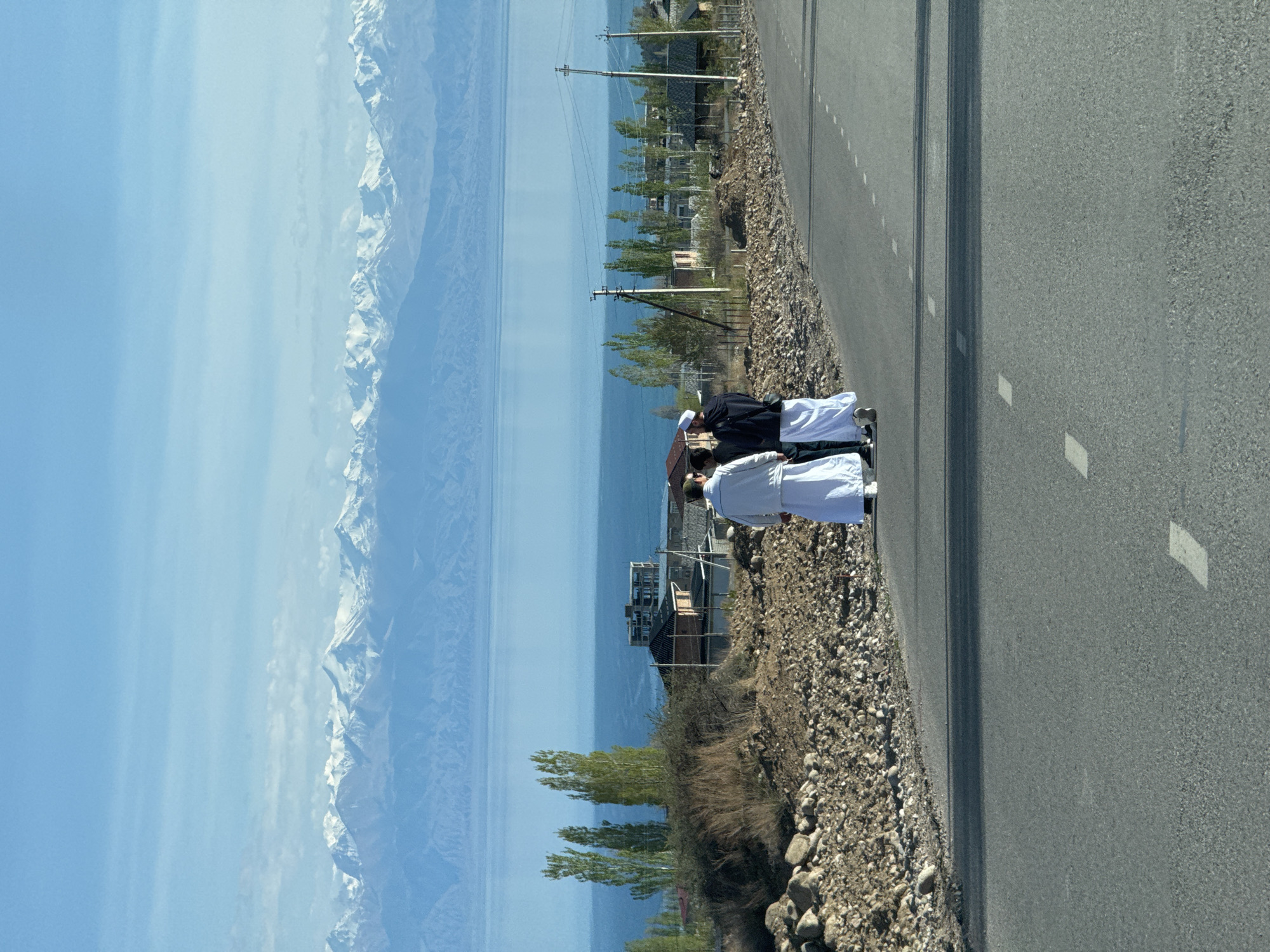 Group gathers roadside in Çolpon-Ata, some in white robes