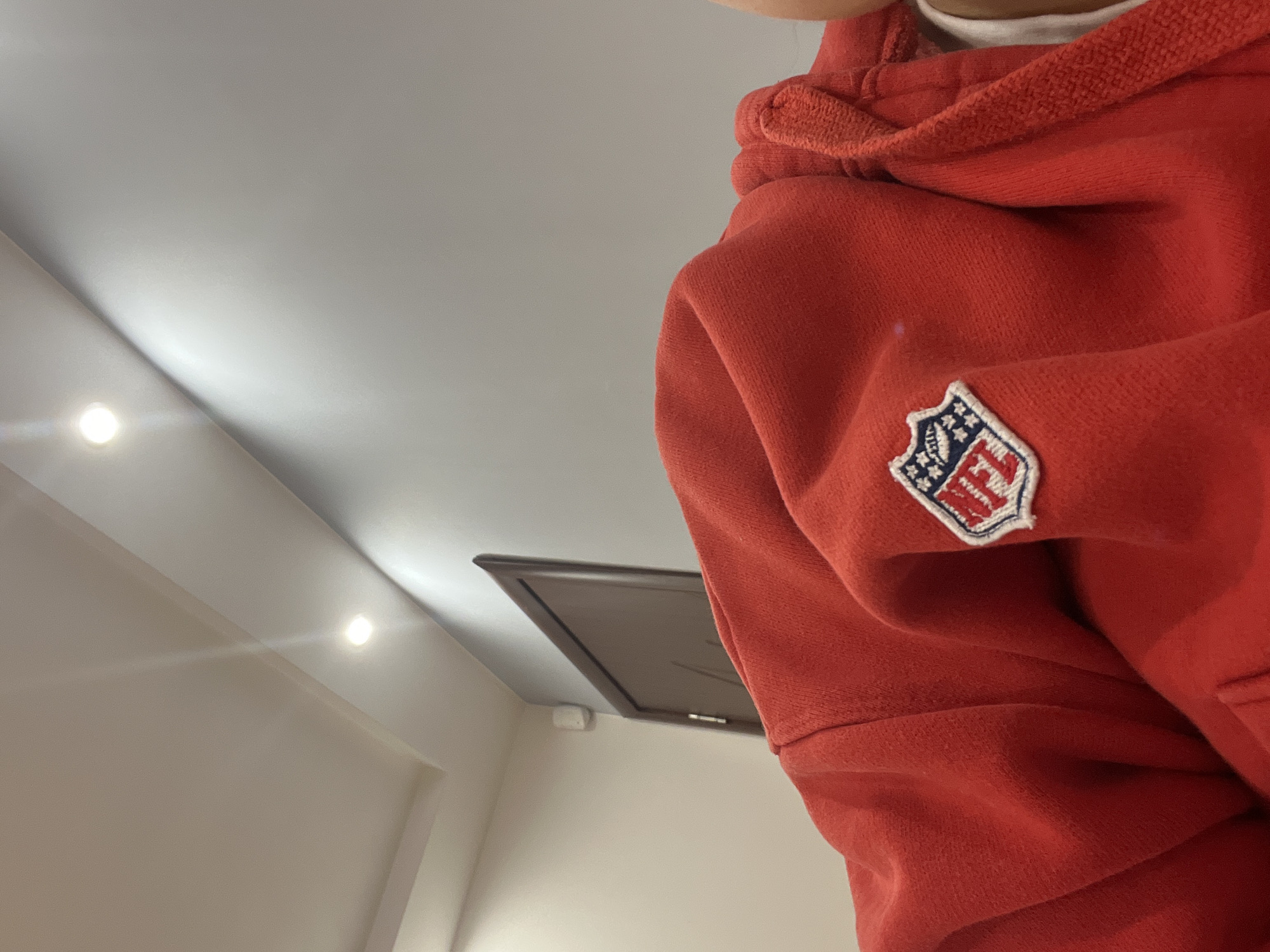 Person in NFL sweatshirt photographed indoors in Pernik