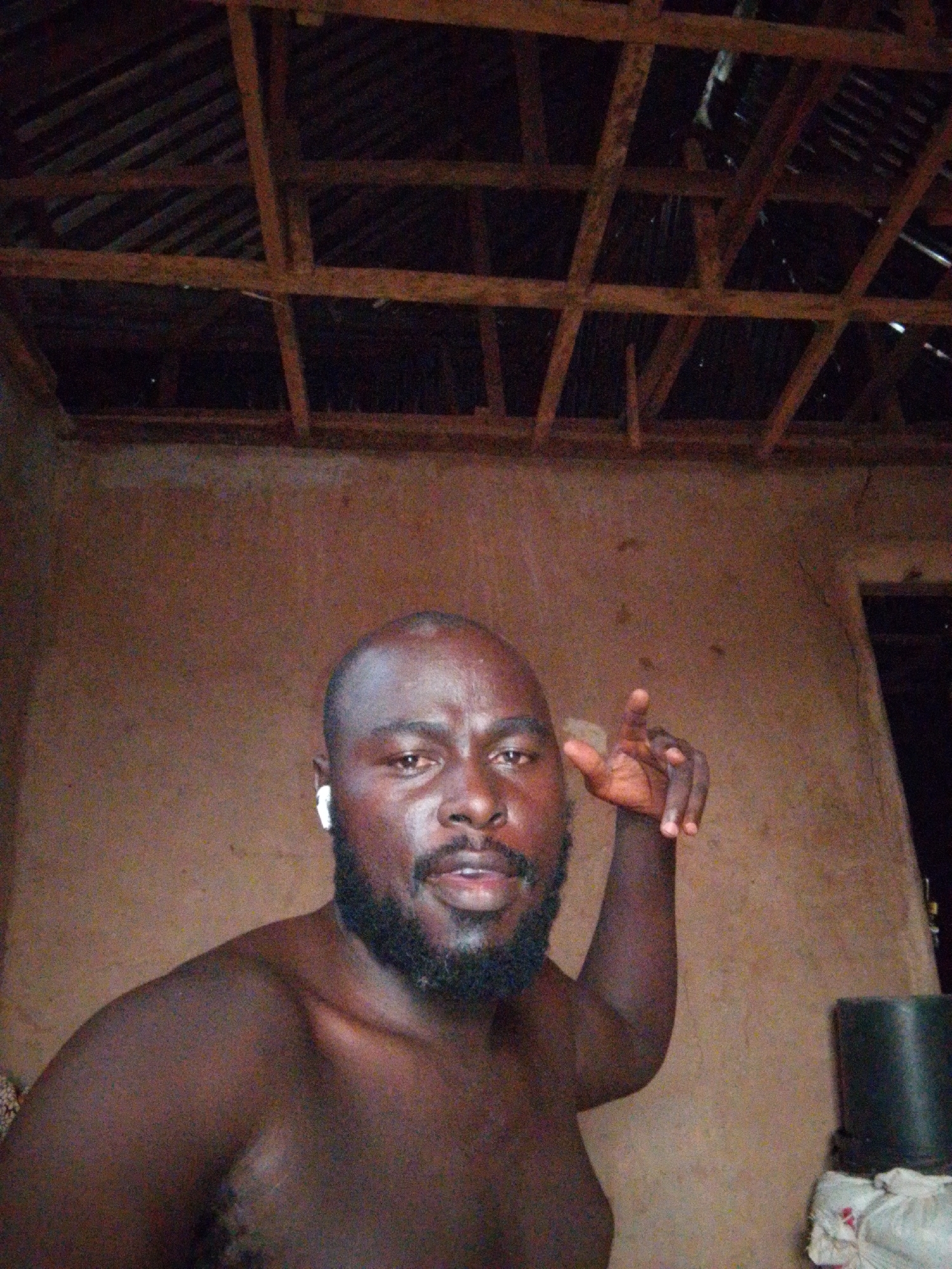 Man observed with earbud, raised hand in Nigerian village