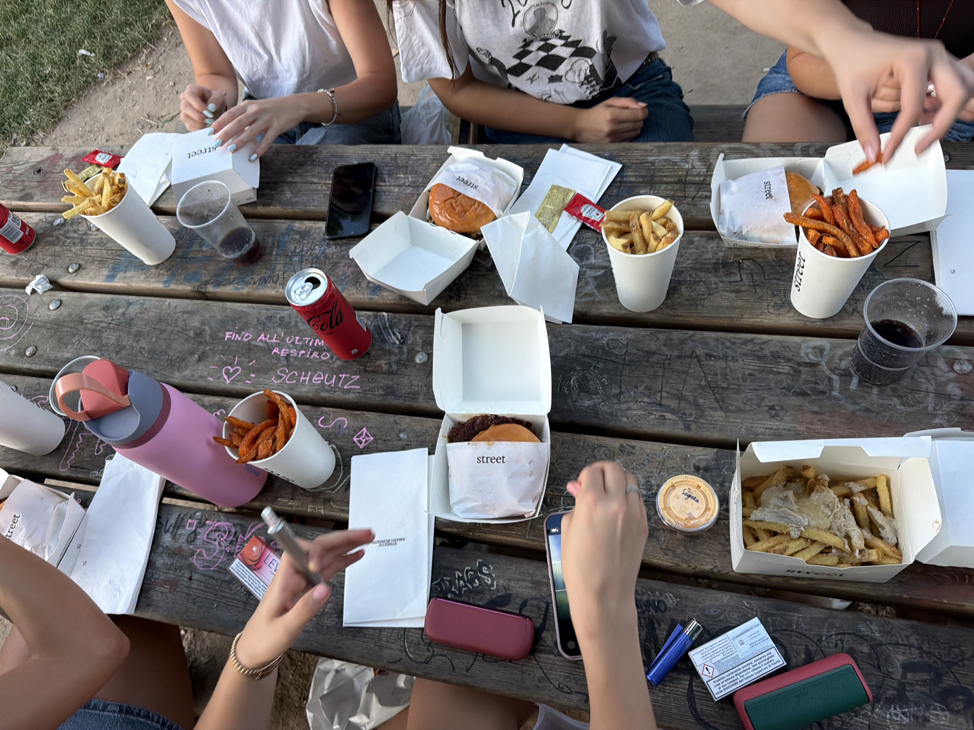 Street food burgers and fries at an outdoor Milan table