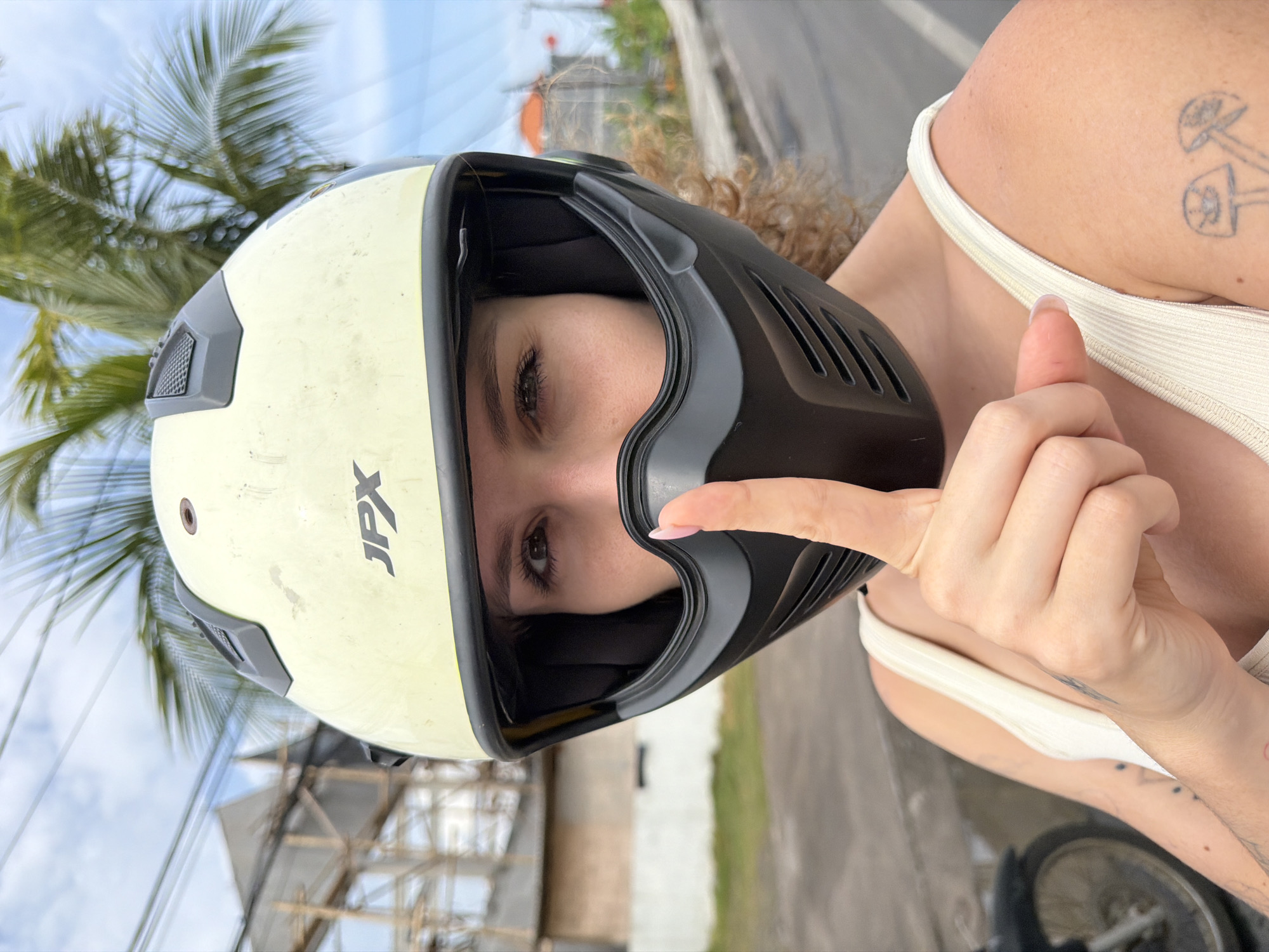 Woman in JPX helmet makes playful gestures during motorcycle ride