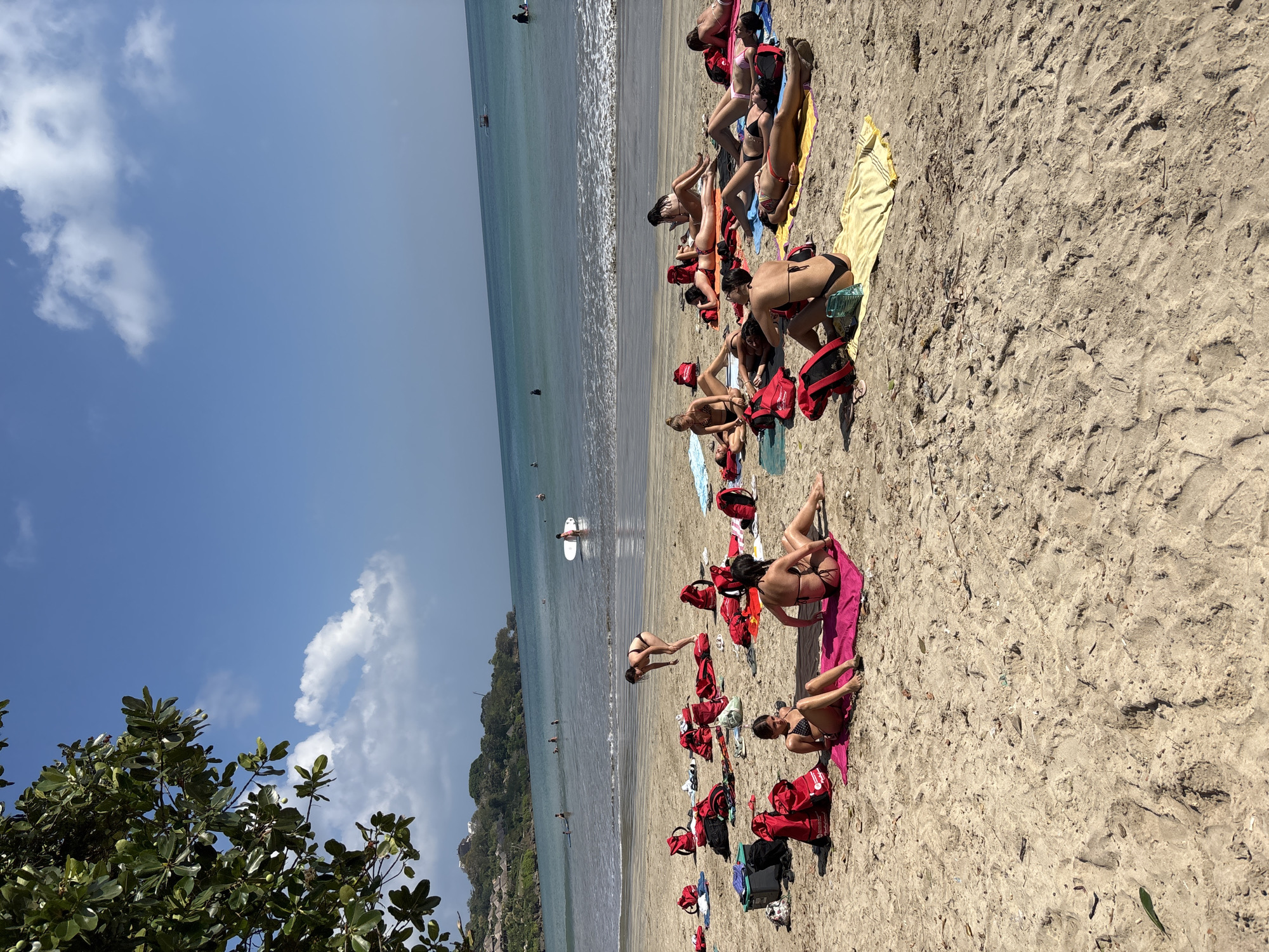 Busy beach day in Kuta Selatan — sunbathers, horses, and fishing boats