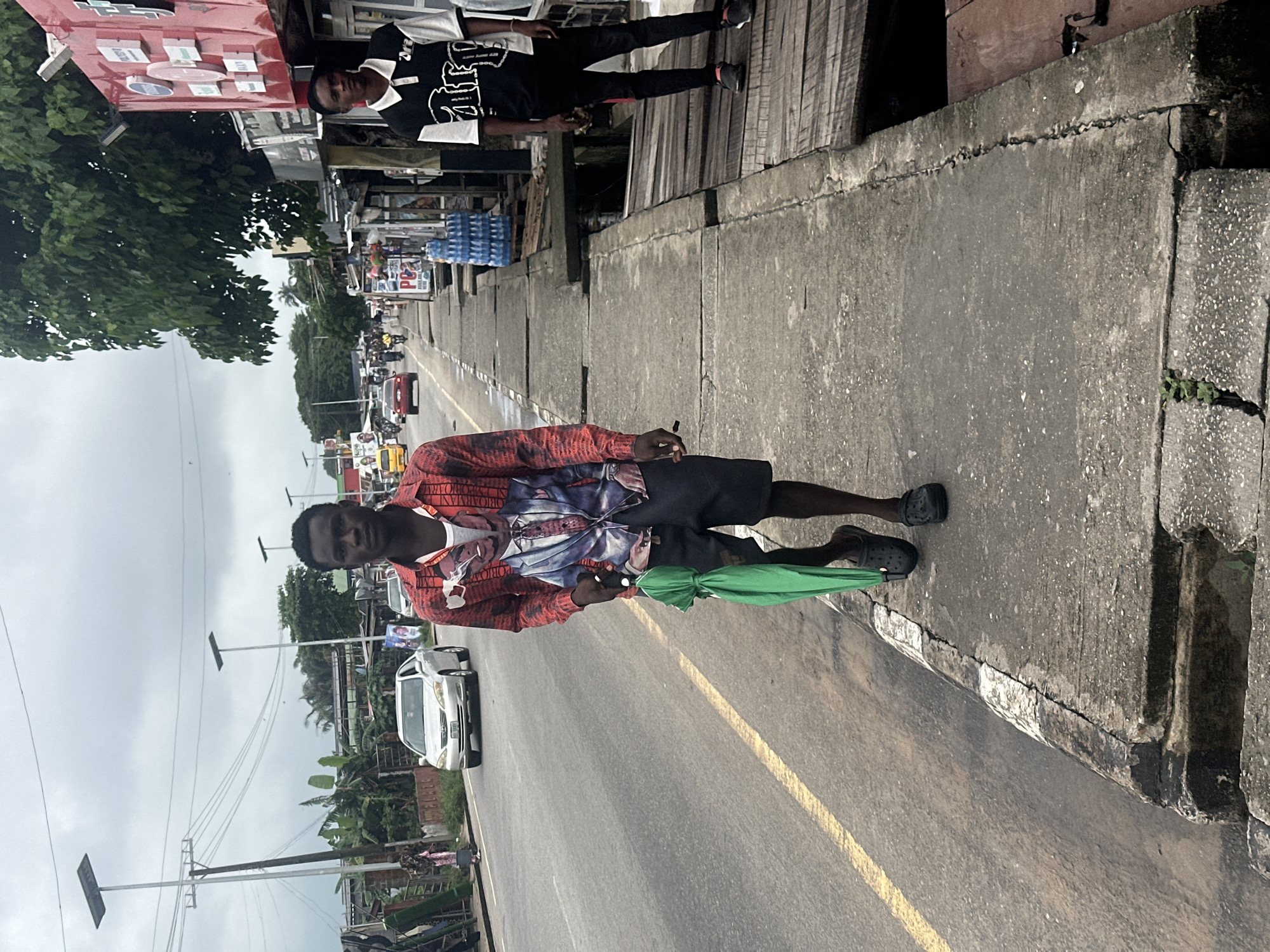 Wet morning street activity along a Badagry commercial strip