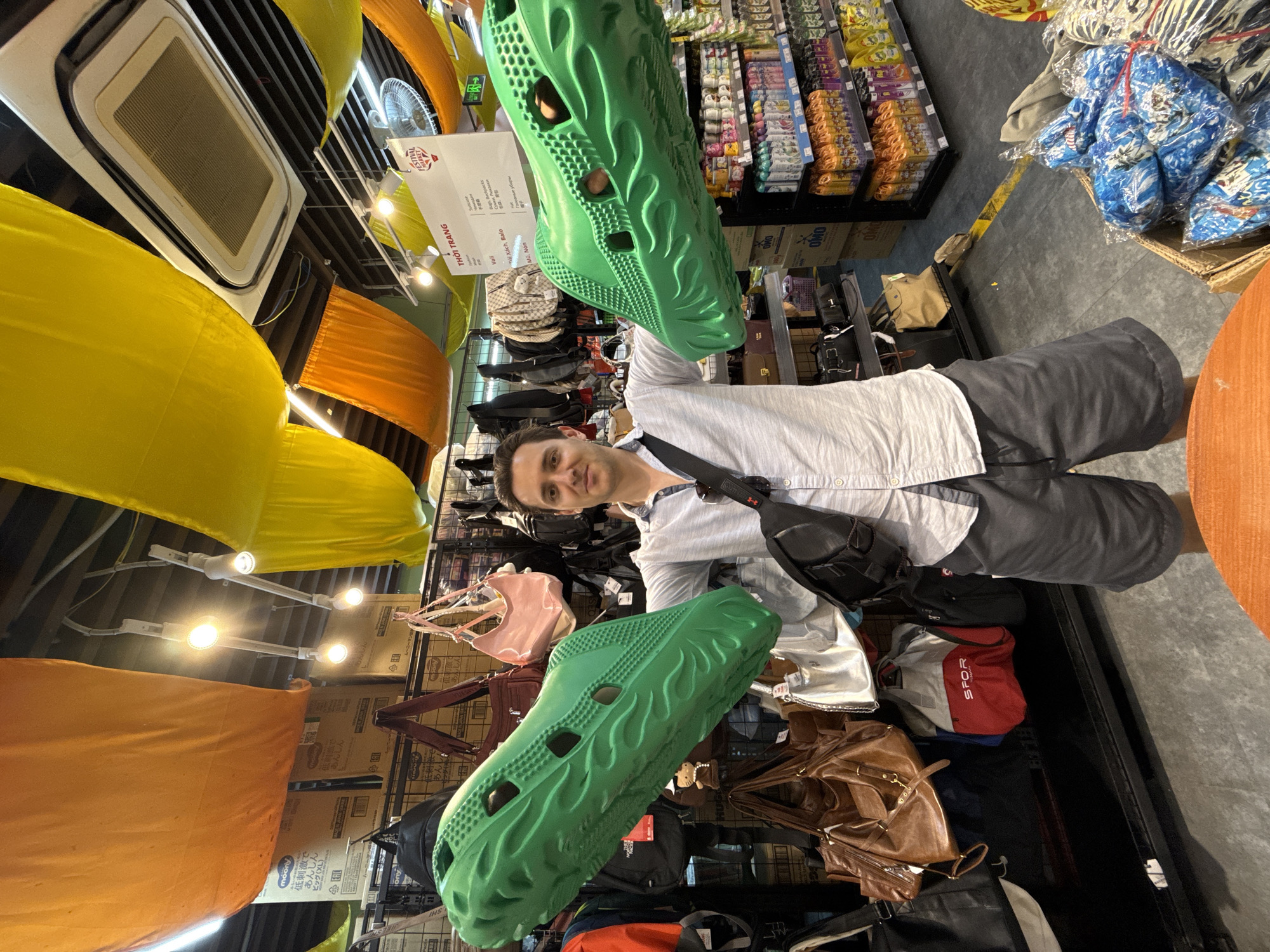 Man examines novelty sandals at Nha Trang retail store