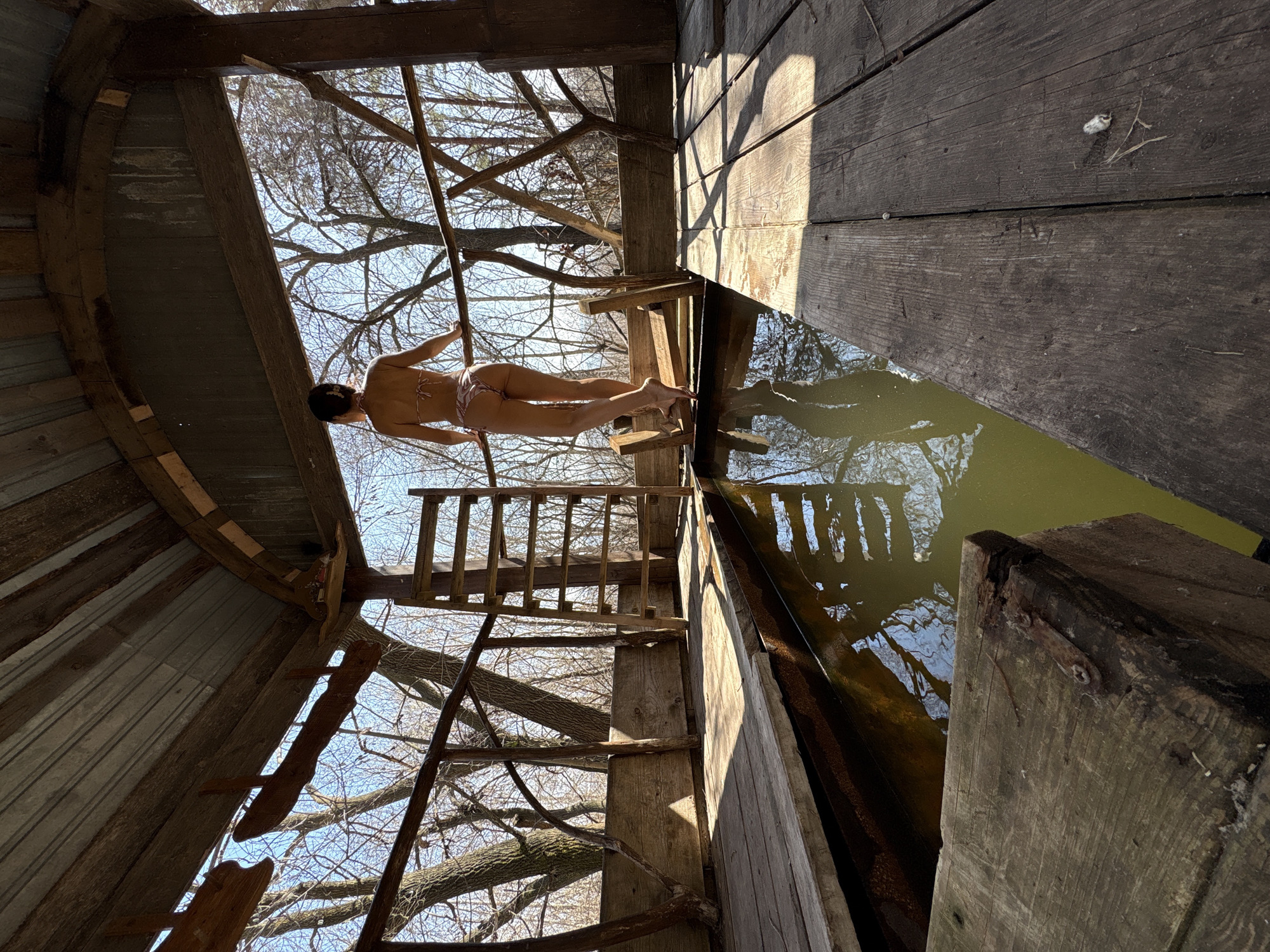 Woman stands on wooden platform over water in Ulyanovsk