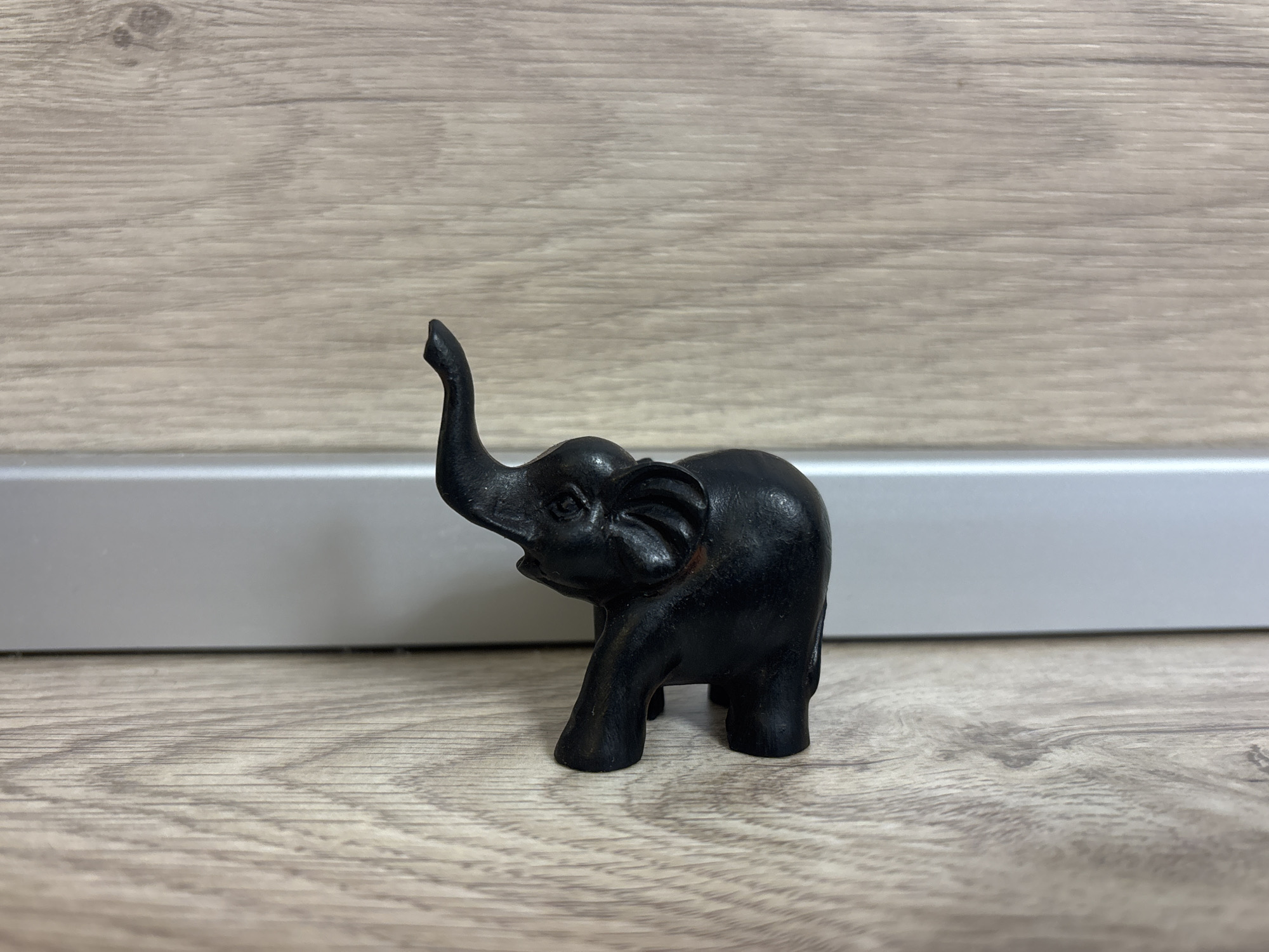 Black elephant figurine spotted on wooden surface