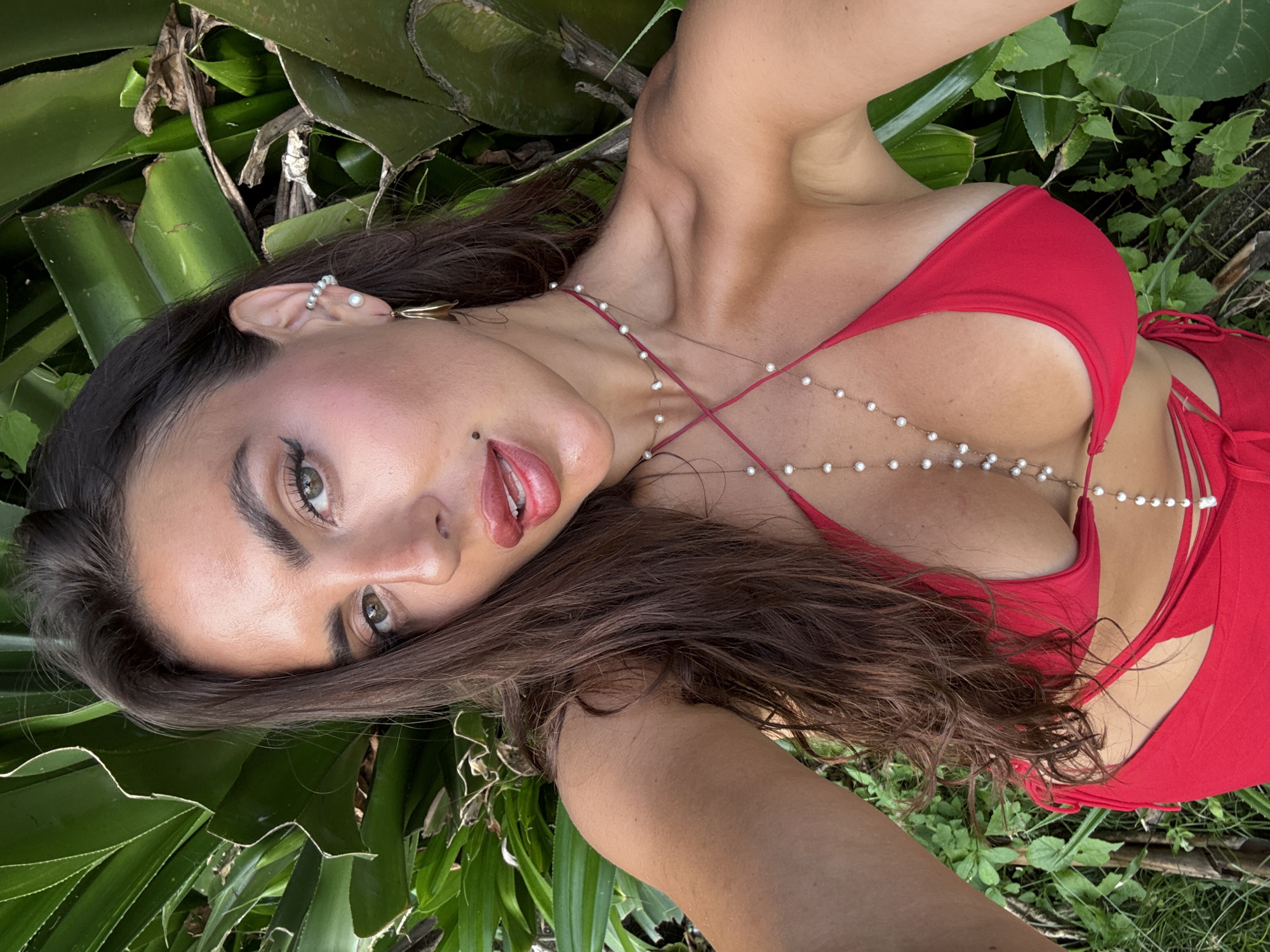 Woman poses in red bikini among tropical plants in Mengwi