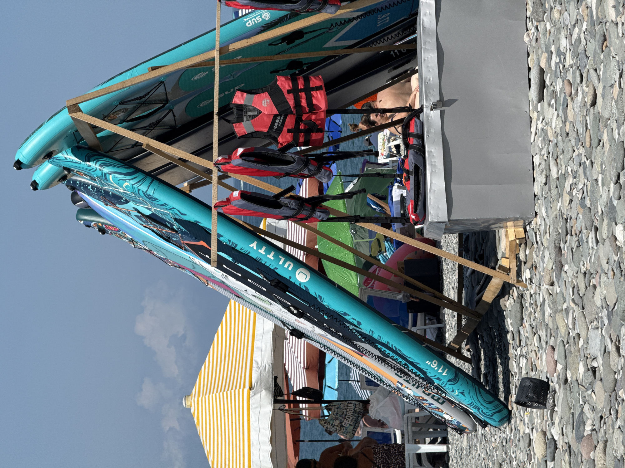 Beach gear, juice stands, and palm-lined walkways on a busy morning