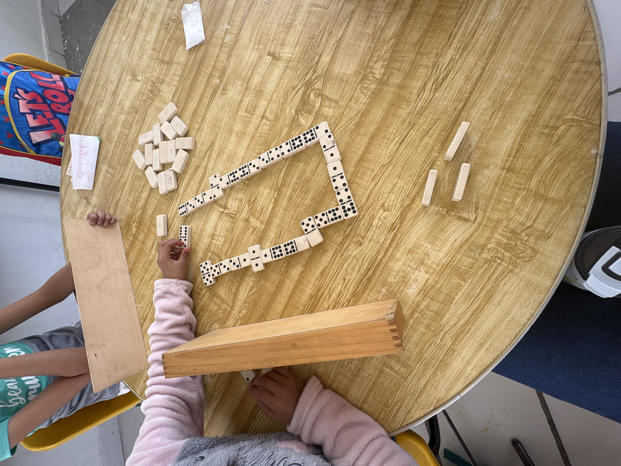 Children play dominoes at table in Puebla