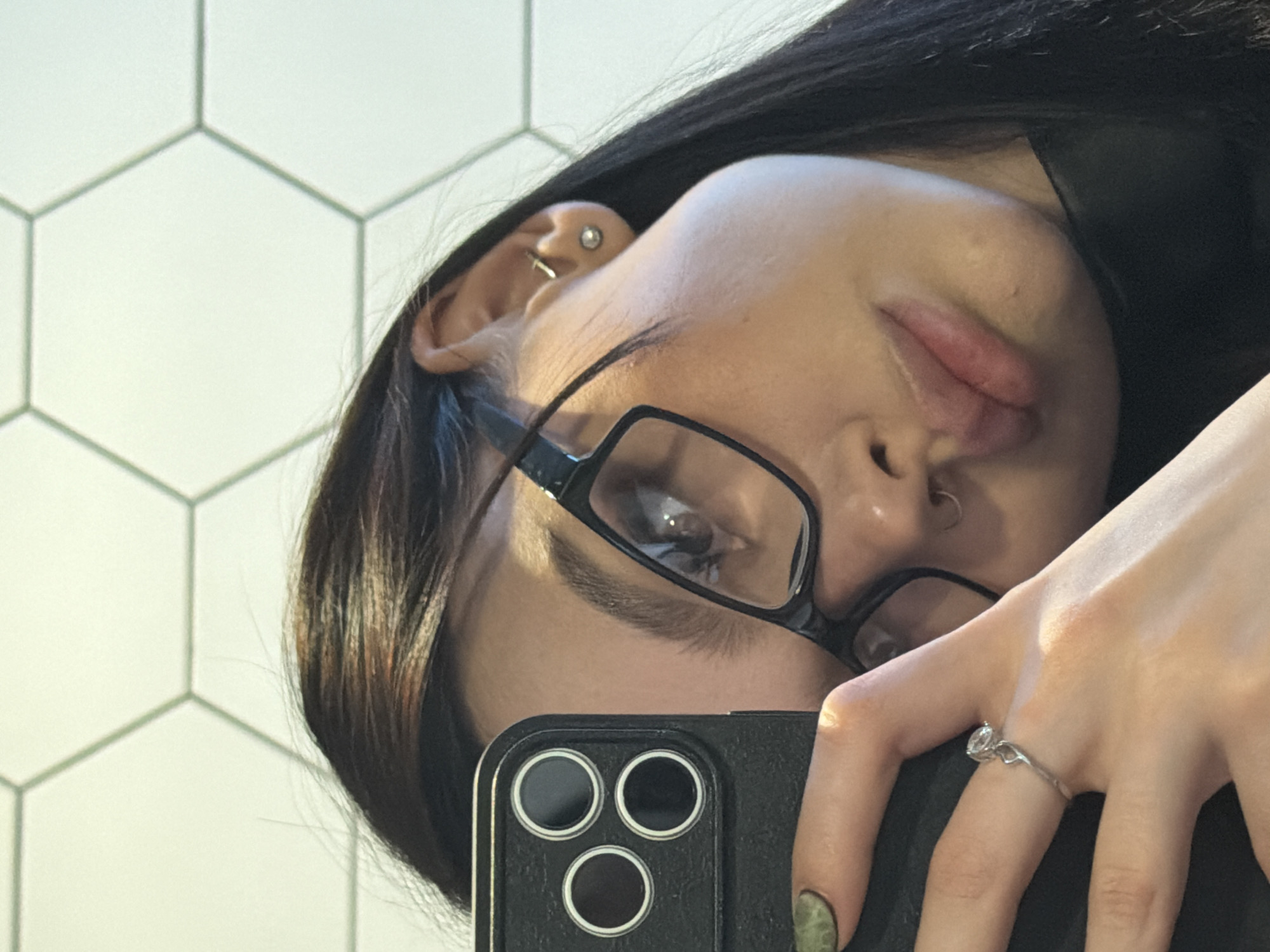 Person takes selfie showing piercings and accessories