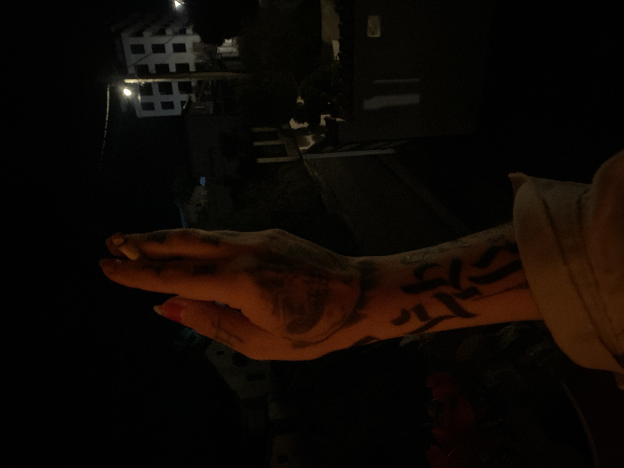 Tattooed woman smoking cigarette in urban night setting