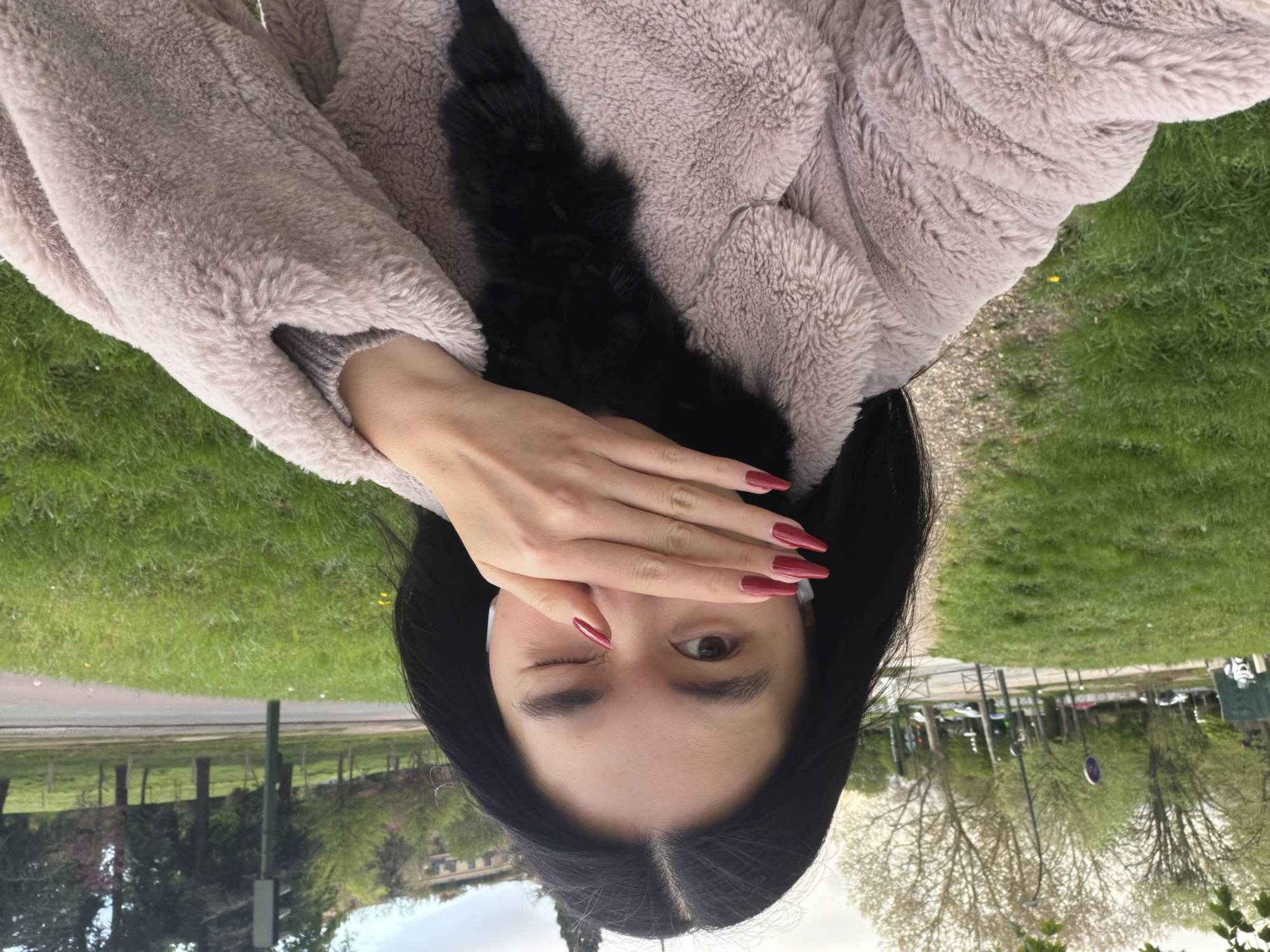 Woman takes playful selfies in Paris park